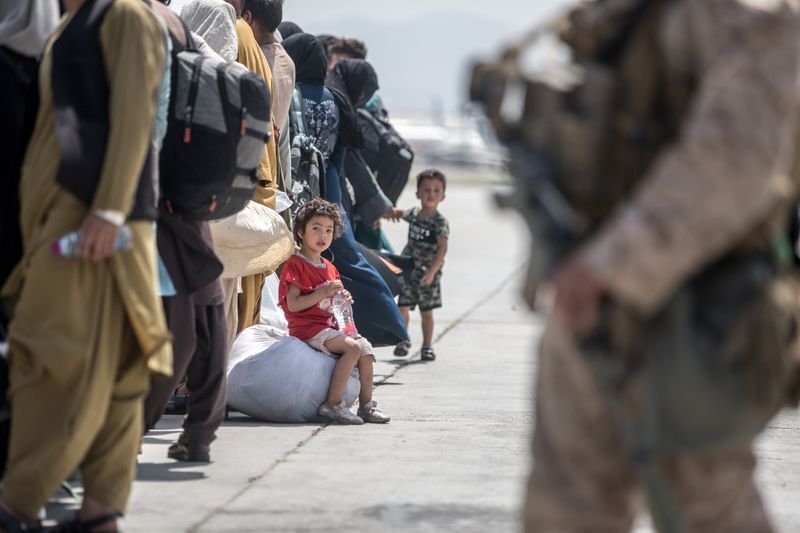 A child waits with her family to board a U.S. Air Force Boeing C-17 Globemaster III during an evacuation at Hamid Karzai International Airport, Afghanistan, August 22, 2021. U.S. Marine Corps/Sgt. Samuel Ruiz/Handout via REUTERS (US MARINES)