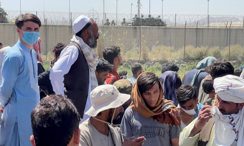 Crowds of people show their documents to U.S. troops outside the airport in Kabul, Afghanistan August 26, 2021. REUTERS/Stringer (STRINGER)