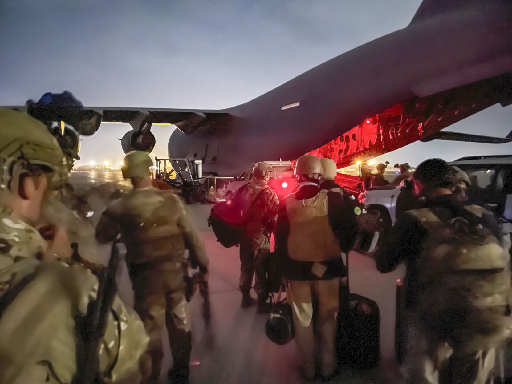U.S. Army paratroopers assigned to the 82nd Airborne Division, and others, prepare to board a C-17 cargo plane at Hamid Karzai International Airport in Kabul, Afghanistan, Monday, Aug. 30, 2021. (Master Sgt. Alexander Burnett/U.S. Army via AP)