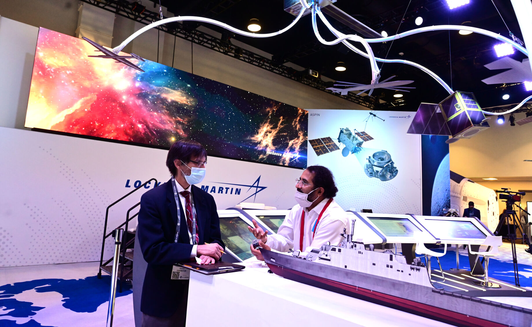 Ray Amin, with Extrude Hone, (right) talks with Kevin Huttenhoff, with Lockheed Martin, at the Lockheed Martin exhibit at the Space Symposium on Tuesday, Aug. 24, 2021. (Photo by Jerilee Bennett, The Gazette) (JERILEE BENNETT THE GAZETTE)