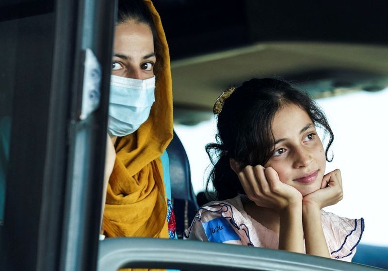 Afghan refugees ride aboard a bus taking them to a refugee processing center last week upon arrival at Dulles International Airport in Dulles, Va. (REUTERS)