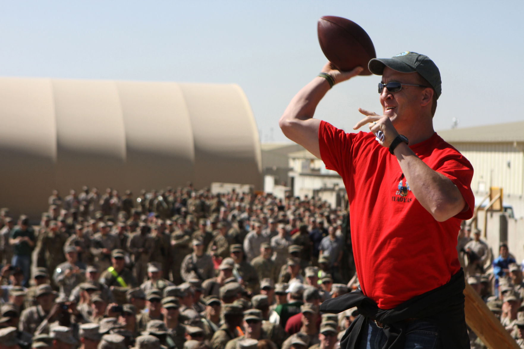 In this Friday, March 1, 2013, photo provided by the U.S. Marines, Denver Broncos NFL football quarterback Peyton Manning demonstrates a quarterback-receiver connection during the USO Spring Troop Visit at Camp Leatherneck in Afghanistan. (AP Photo/U.S. Marines, Sgt. Bryan A. Peterson) (Sgt. Bryan A. Peterson)