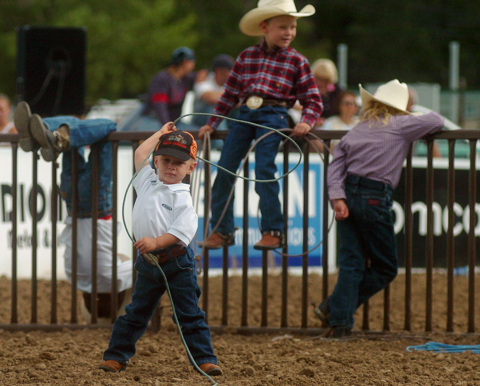 Reece Wadhams of Pueblo warms up before the goat roping event at the Colorado State Fair in Pueblo on Tuesday, Aug. 24, 2004. In the background Denton Ward, back left, hangs on the fence as he sits with Noah Archilise, back center, and Reichle Arcilise. The Gazette, Bryan Oller (Bryan Oller)