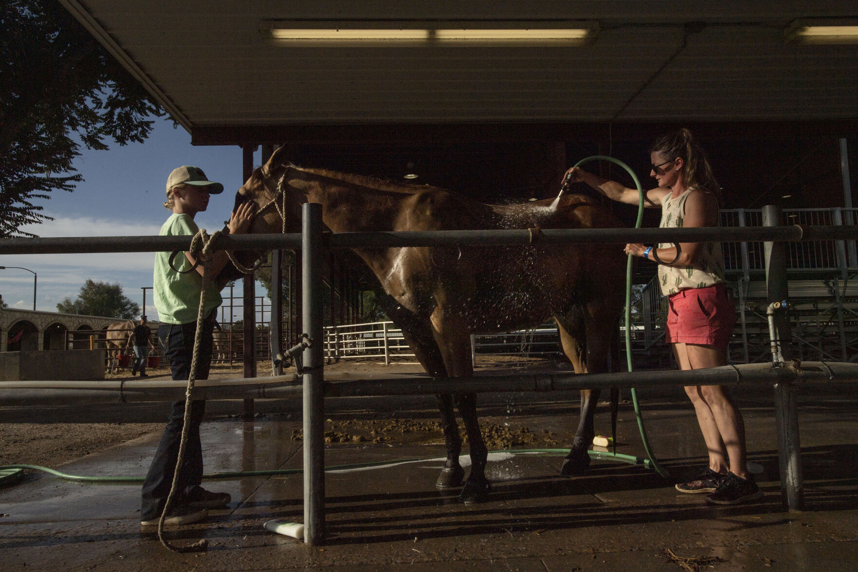 Addisyn Grilli, 10, and her mother Mandy Grilli give their horse a bath after the horse show during the Colorado State Fair in Pueblo, Colo., on Friday, August 27, 2021. The fair kicked off on Friday and runs through Sept. 6. at the Colorado State Fairgrounds. (Chancey Bush/ The Gazette) (Chancey Bush/ The Gazette)