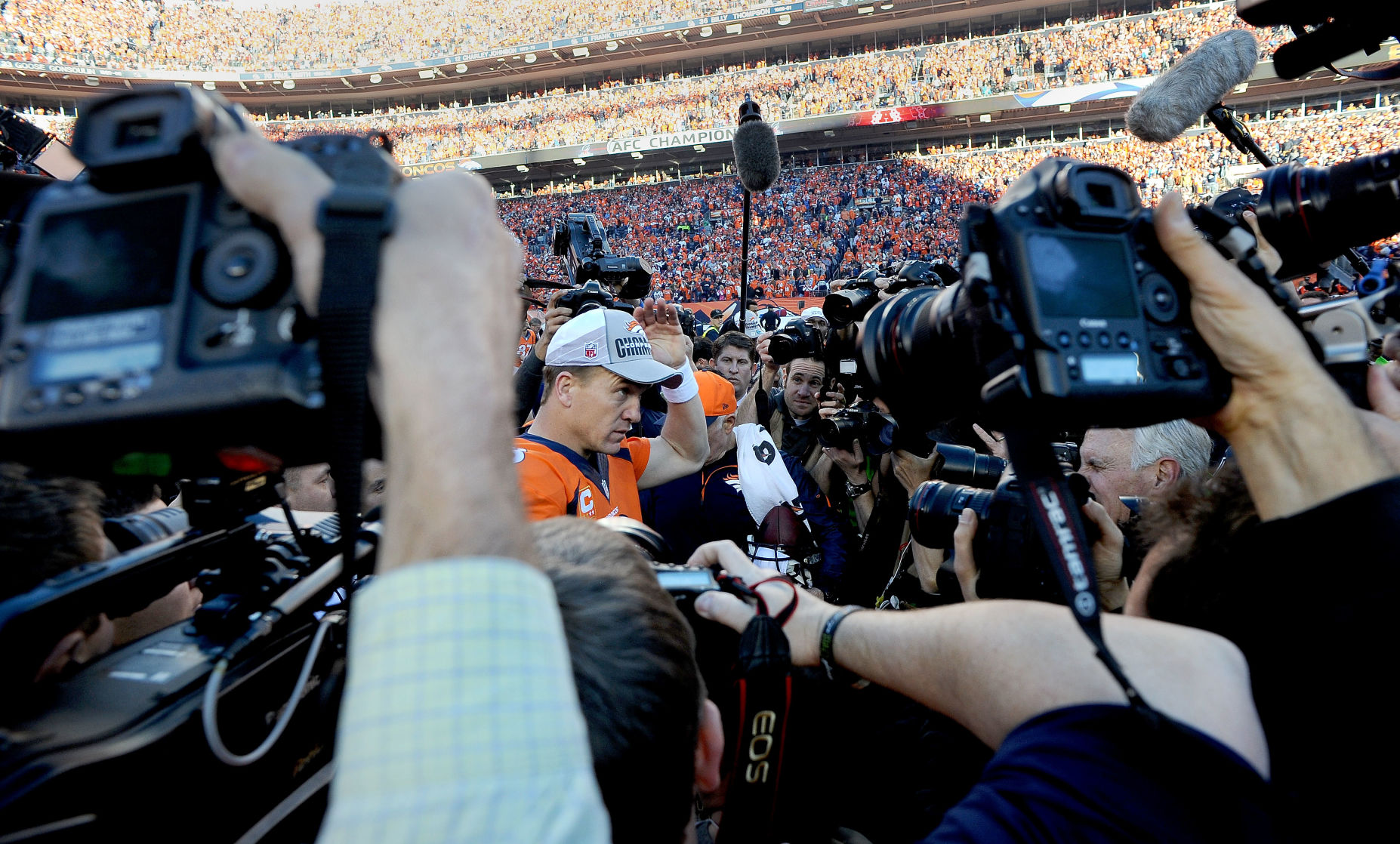 Broncos quarterback Peyton Manning puts on a AFC Champion hat after the Broncos defeating the Patriots 26-16 to win the AFC Championship Sunday, Jan. 19, 2014, at Sports Authority Field at Mile High in Denver to earn a trip to the Super Bowl. (The Gazette, Christian Murdock) (CHRISTIAN MURDOCK)