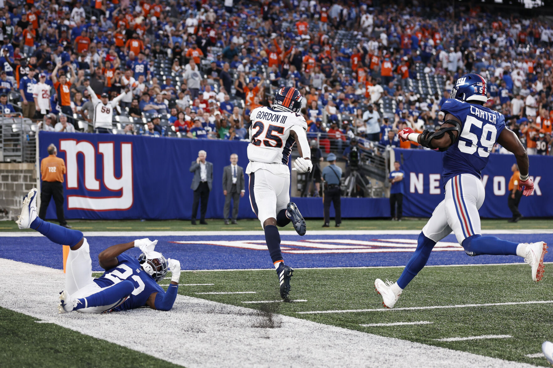 Denver Broncos running back Melvin Gordon (25) runs past New York Giants' Adoree' Jackson (22) and Lorenzo Carter (59) for a touchdown during the second half of an NFL game Sunday, Sept. 12, 2021, in East Rutherford, N.J. The Broncos won 27-13. (AP Photo/Adam Hunger) (Adam Hunger)