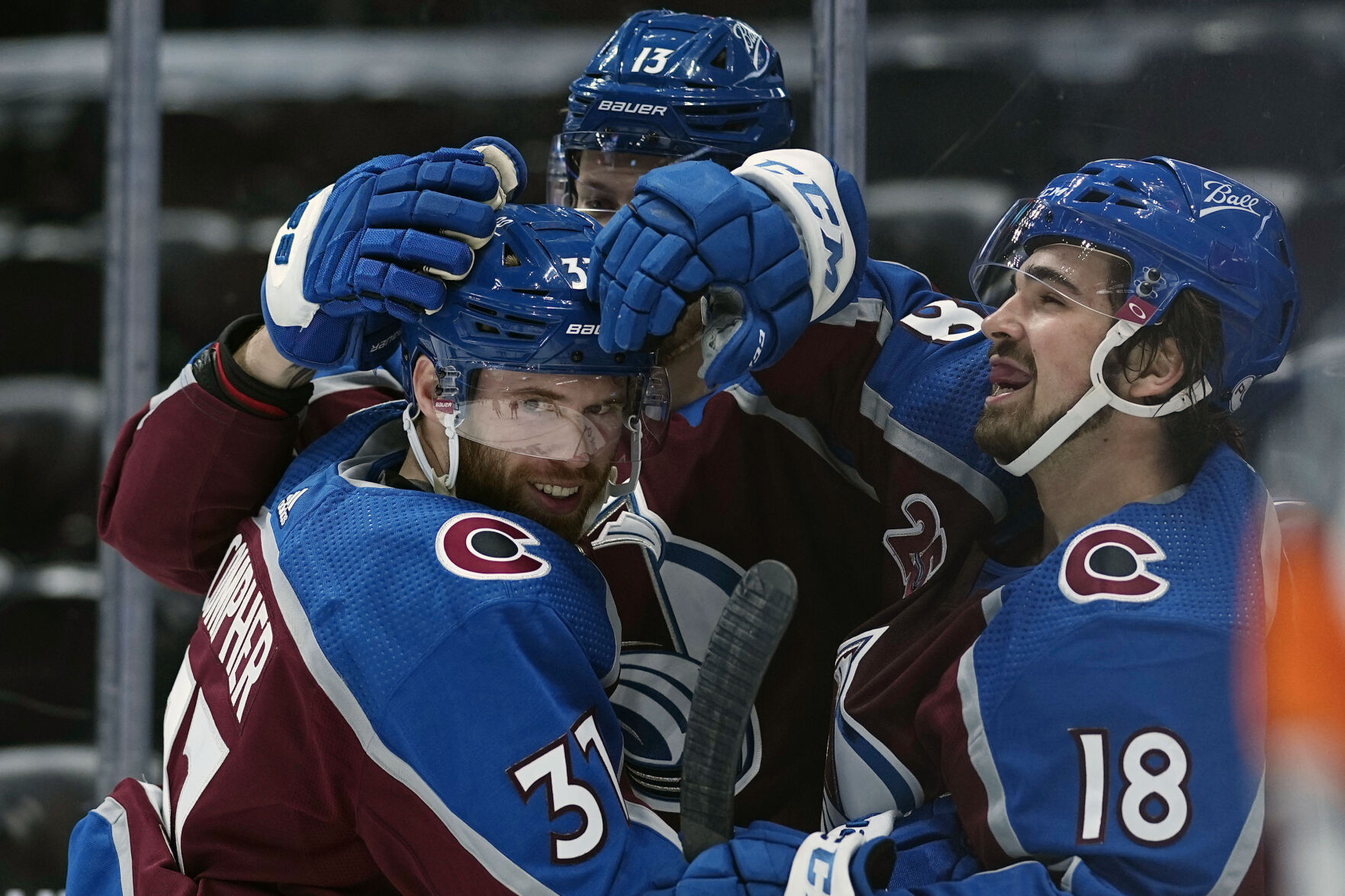 Colorado left wing J.T. Compher, left, is congratulated by teammates Valeri Nichushkin and Alex Newhook, right, after scoring a hat trick against the Kings on May 12 in Denver. (The Associated Press)