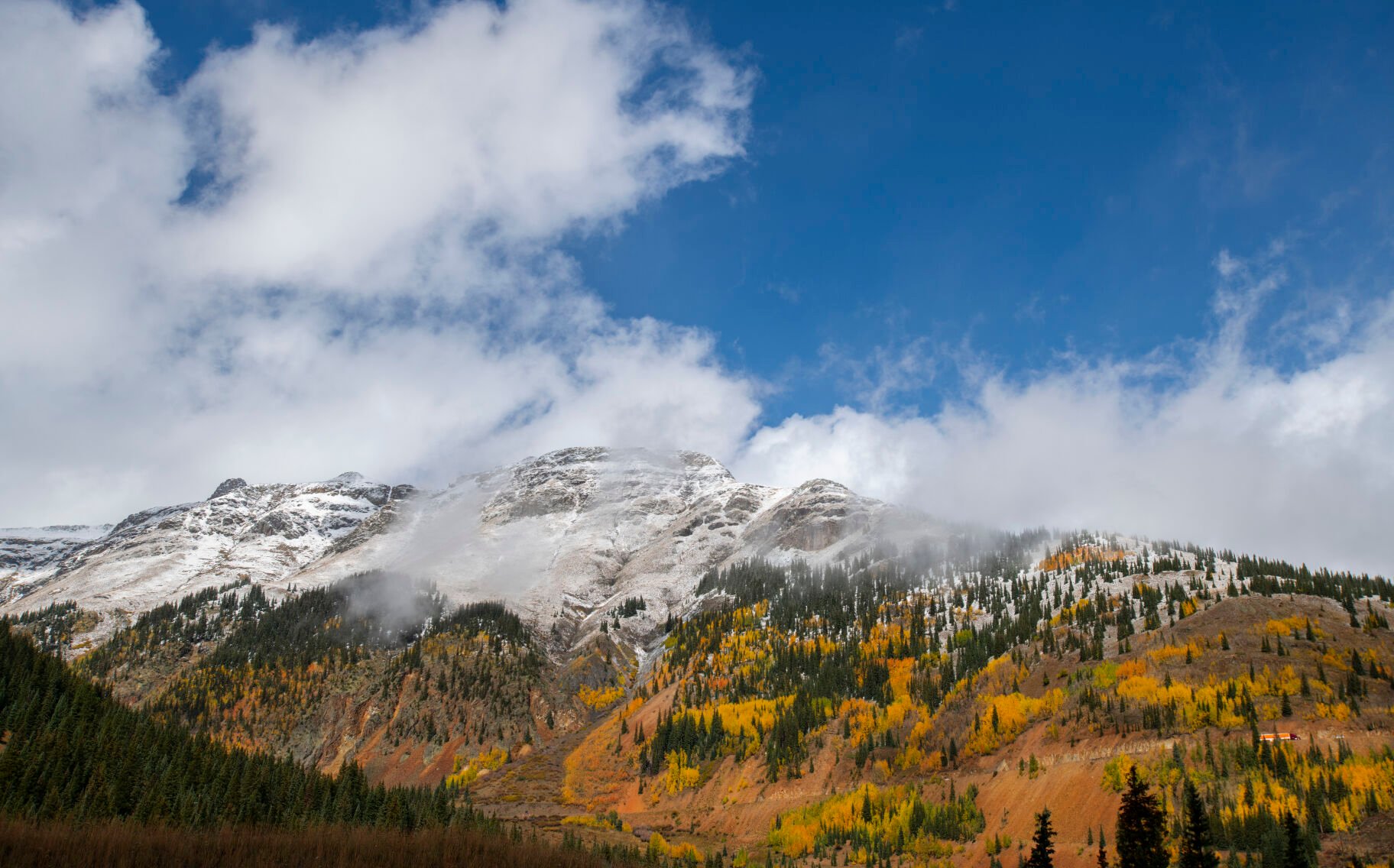 The clouds break revealing the snow-capped mountains on 11,018-foot Red Mountain Pass between Silverton and Ouray, Colo., Wednesday, Sept. 29, 2021. (The Gazette, Christian Murdock) (Christian Murdock/The Gazette)