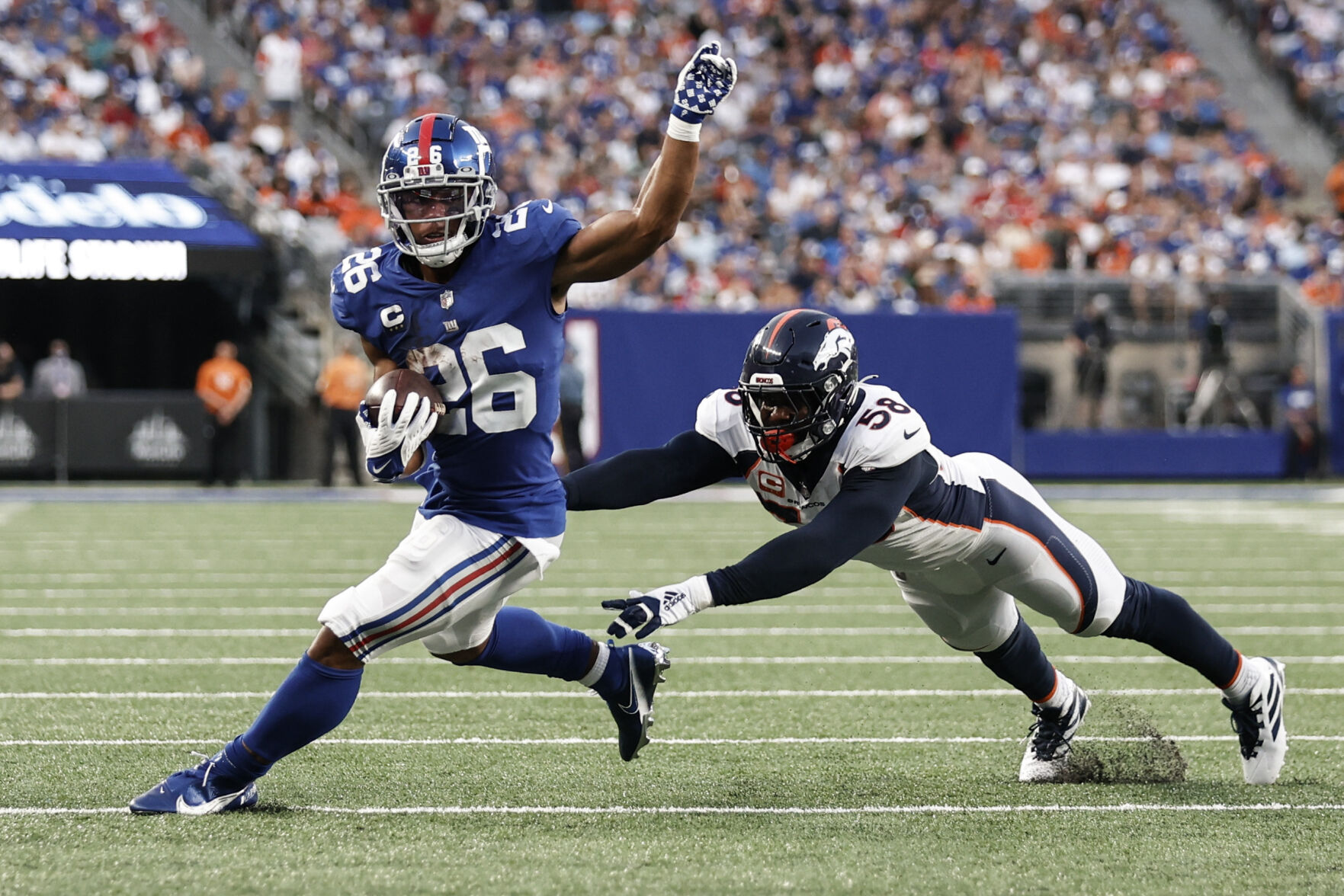 New York Giants running back Saquon Barkley (26) runs away from Denver Broncos' Von Miller (58) during the second half of an NFL game Sunday, Sept. 12, 2021, in East Rutherford, N.J. The Broncos won 27-13. (AP Photo/Adam Hunger) (GeorgeStoiaBroncos beat writergeorge.stoia@gazette.comhttps://secure.gravatar.com/avatar/5b8854c53e77d2068c18c16523197323?d=mm&r=g)