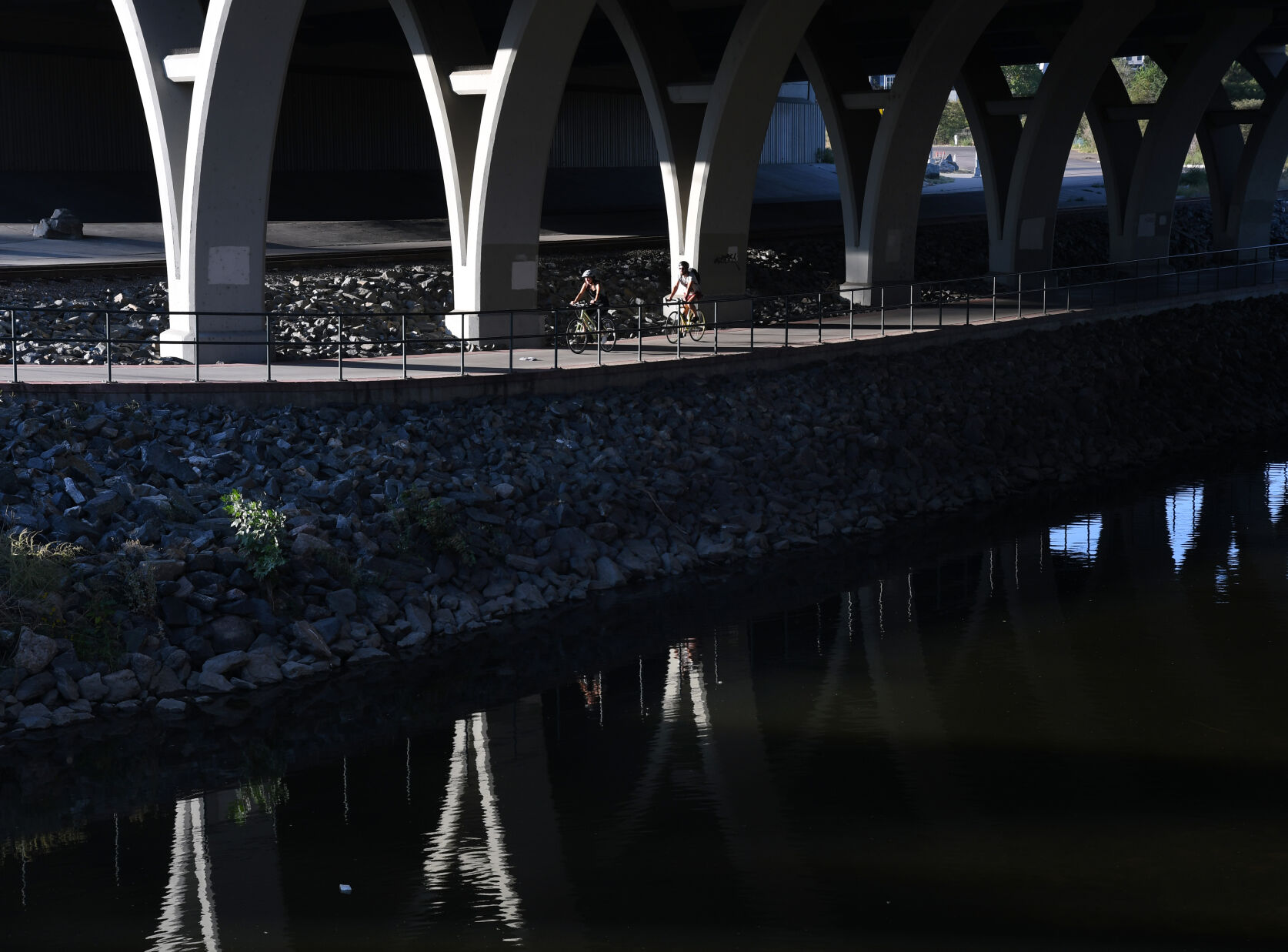 Cyclists, runners, and pedestrians use the pathways that wind along the South Platte River underneath the Colfax Avenue viaduct and Interstate 25. (Kathryn Scott)