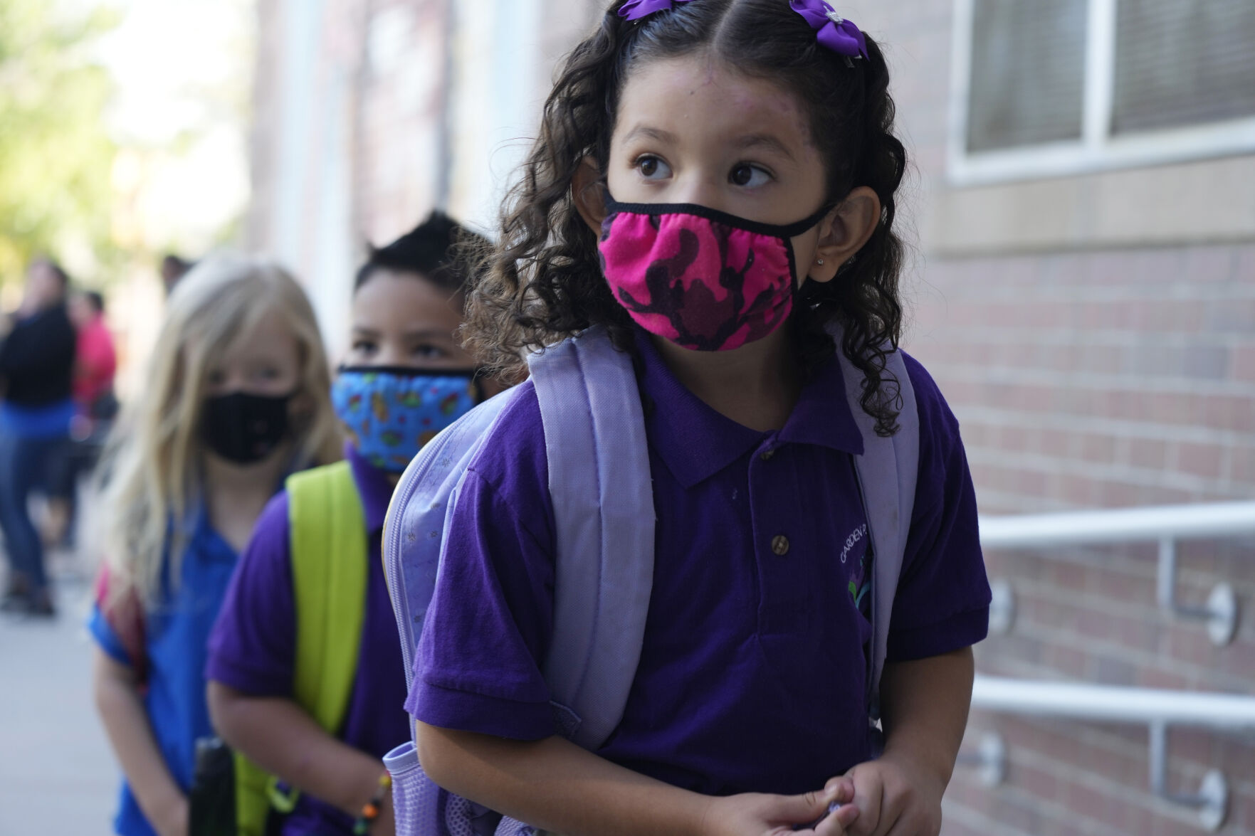 Students wear face coverings as they head into the building for the first day of in-class learning since the start of the pandemic at Garden Place Elementary School, Monday, Aug. 23, 2021, in north Denver. All students, visitors and staff are required to wear face coverings while in Denver Public Schools regardless of vaccination status with the start of the school year. (David Zalubowski - staff, AP)