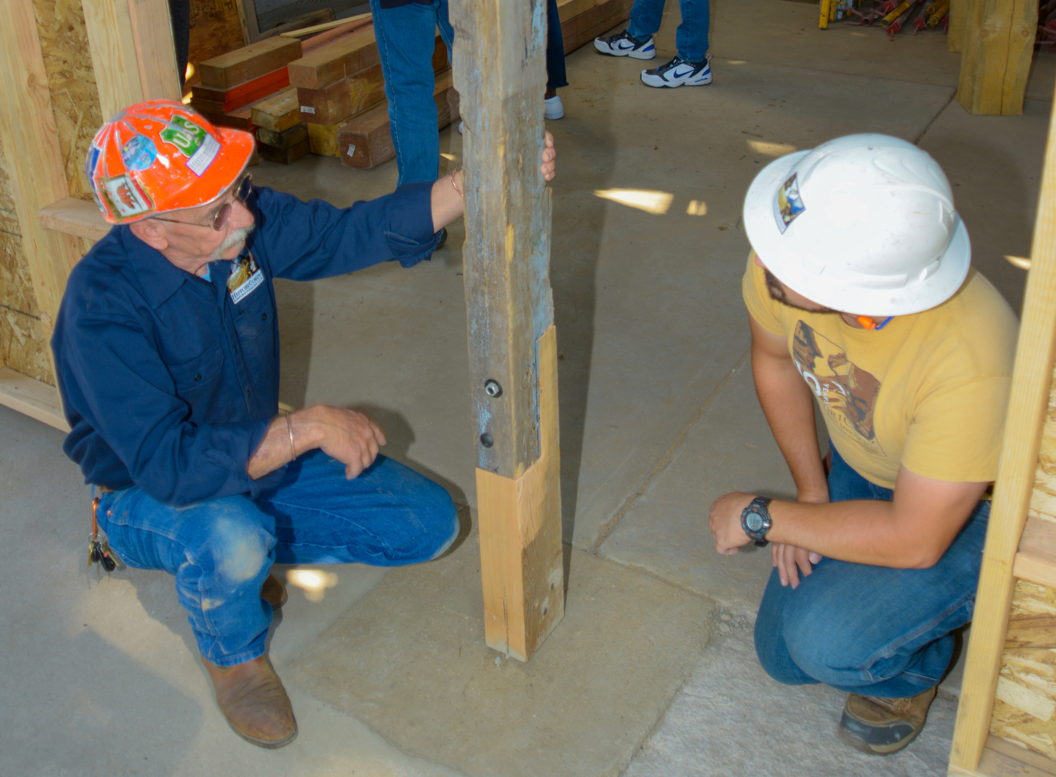 Dane Cowan, project supervisor and Daniel Ensalaco, crew leader for HistoriCorp's restoration of a circa 1935 Civilian Conservation Corp garage at Katherine Craig Park examine an historically-correct repair to a rotted support post performed by workers in Denver Mayor Michael Hancock's Workforce Historic Preservation Training Program