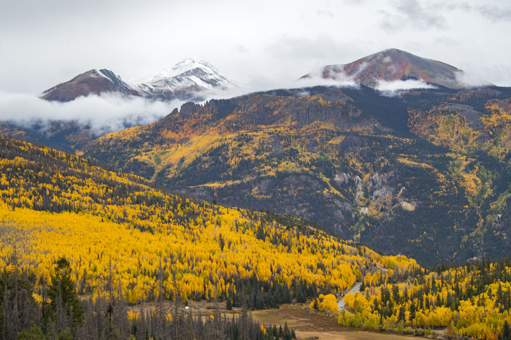 A car drives down 11,530-foot Slumgullion Pass through the changing aspens toward Lake City, Colo., Tuesday, Sept. 28, 2021. (The Gazette, Christian Murdock) (Christian Murdock/The Gazette)