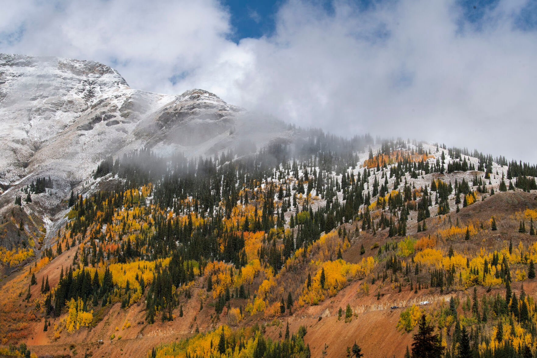 The clouds break revealing the snow-capped mountains on 11,018-foot Red Mountain Pass between Silverton and Ouray, Colo., Wednesday, Sept. 29, 2021. (The Gazette, Christian Murdock) (Christian Murdock/The Gazette)