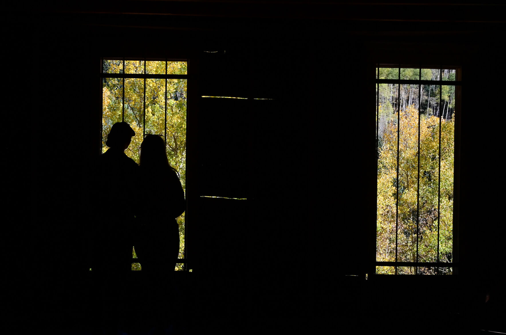 Draven Romero and Melissa Rodriguez, from Colorado Springs, look out at the aspen colors through the windows of the Bird House Hotel on Wednesday, Sept. 22, 2021. In 1883, Ashcroft, Colorado was a town with a population of perhaps 2,000 with two newspapers, a school, sawmills, a small smelter, and 20 saloons—bigger than Aspen at the time. Ashcroft is 11 miles south of Aspen on Castle Creek Rd. (Photo by Jerilee Bennett, The Gazette) (Jerilee Bennett)
