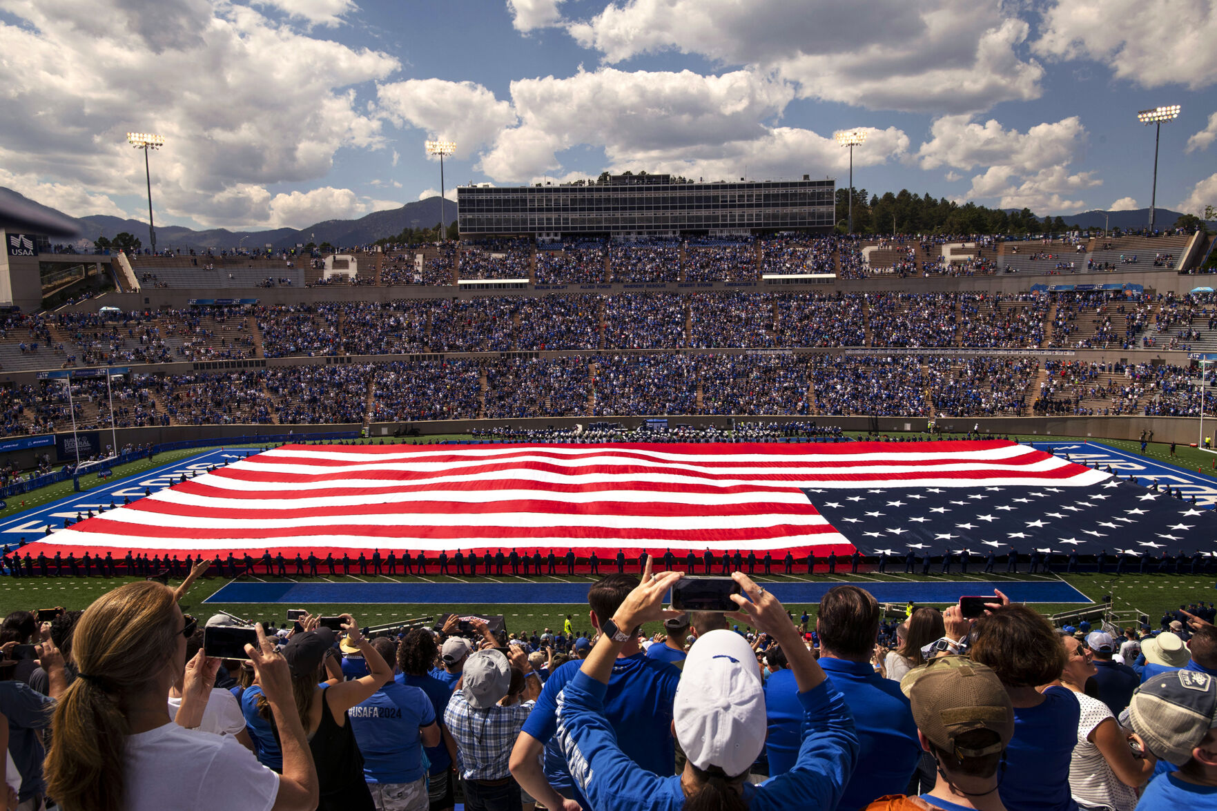Cadets hold a field-length U.S. flag during halftime Saturday at Falcon Stadium. More than 30,000 fans were in attendance. (Chancey Bush, The Gazette)