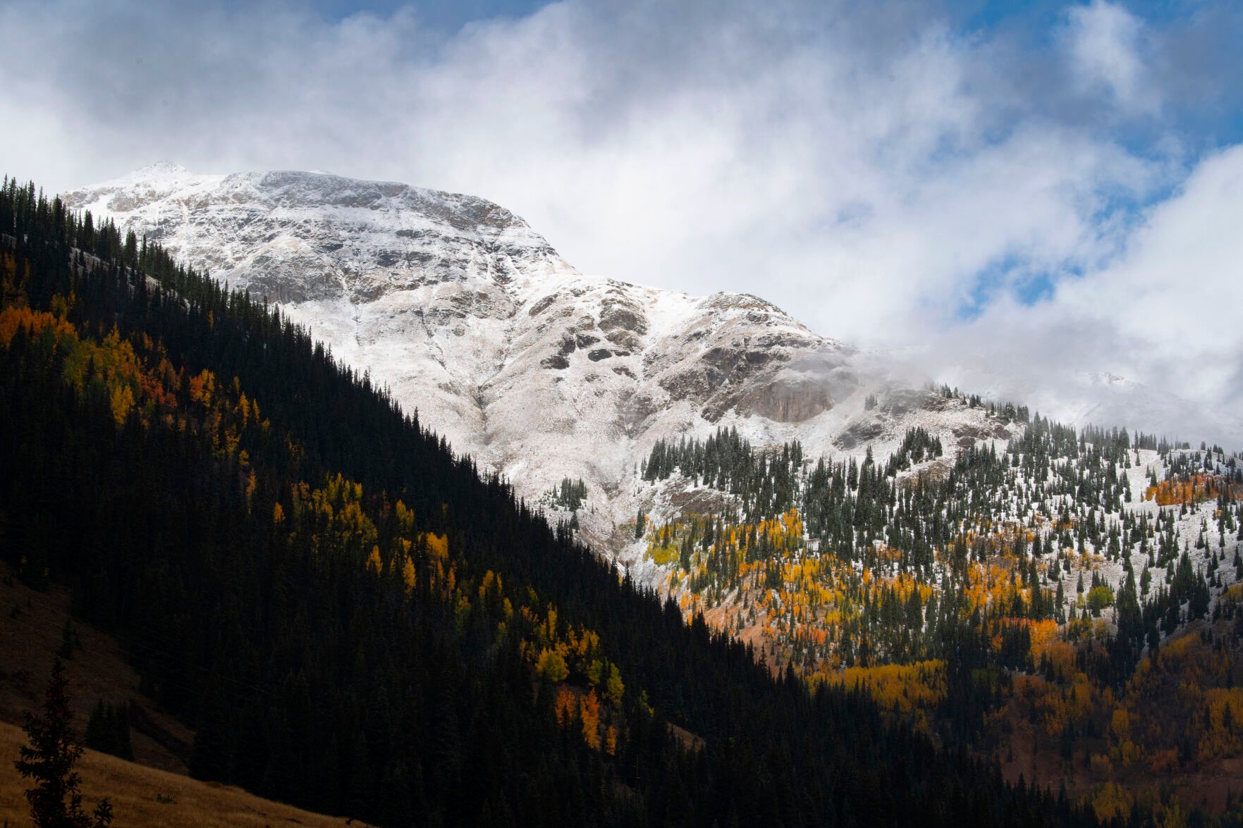The clouds break revealing the snow-capped mountains on 11,018-foot Red Mountain Pass between Silverton and Ouray, Colo., Wednesday, Sept. 29, 2021. (The Gazette, Christian Murdock) (Christian Murdock/The Gazette)