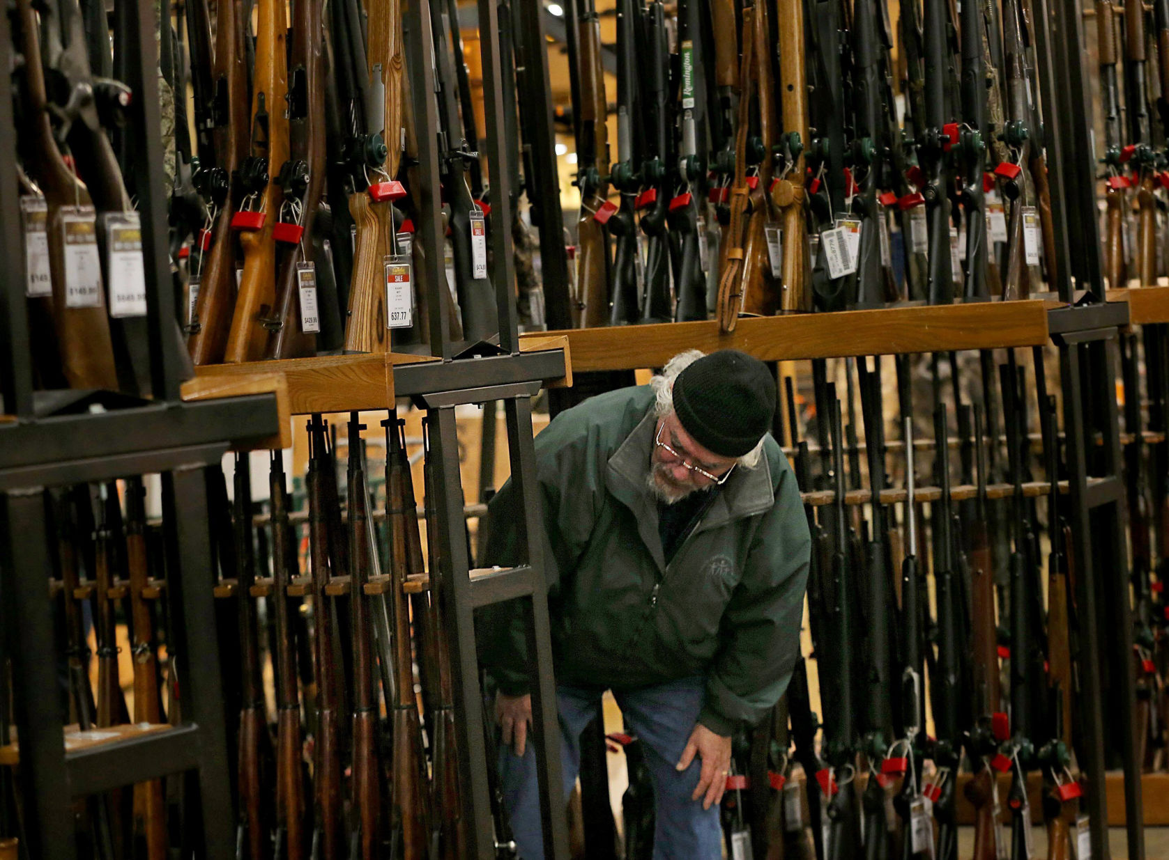 A man looks at the shotgun section of Cabela’s while shopping on Black Friday. (The Associated Press)