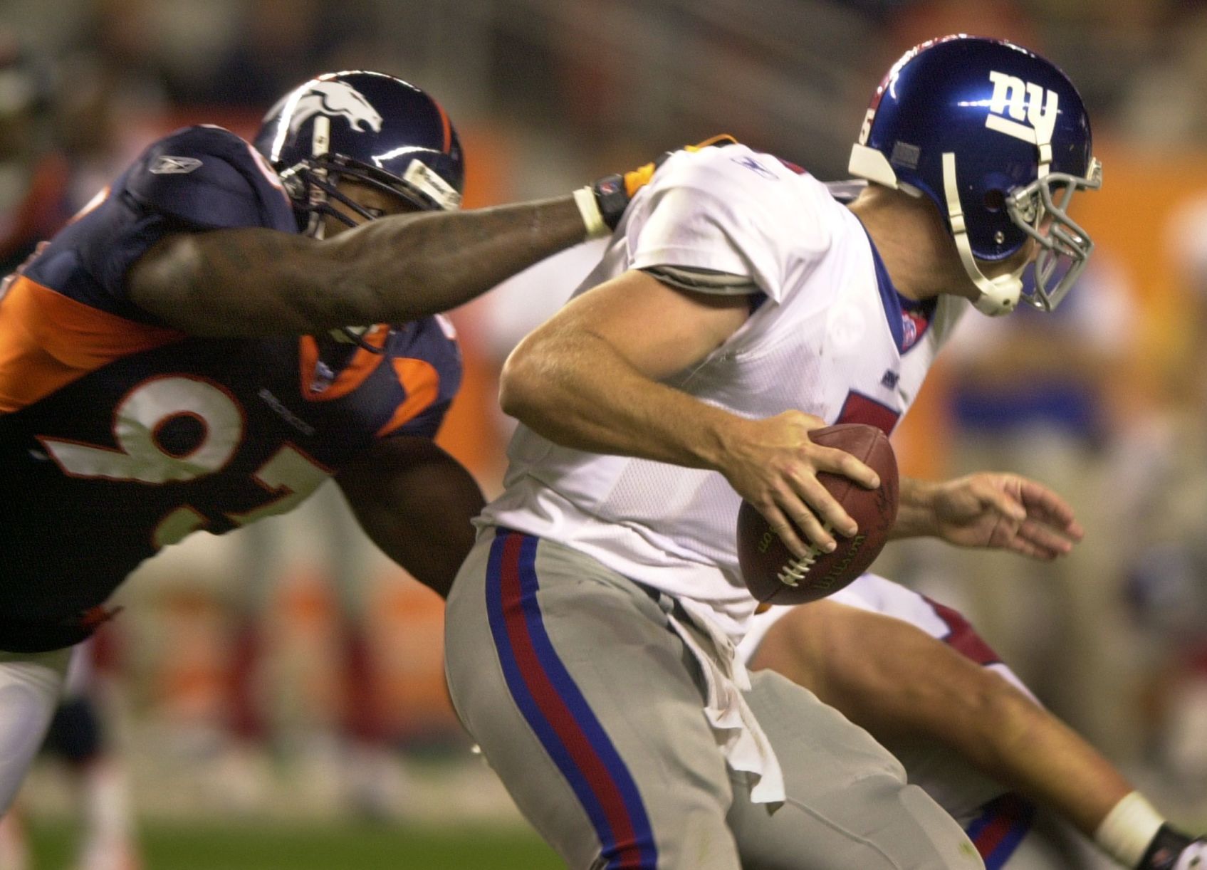 Bronco defensive tackle Trevor Pryce sacks New York quarterback Kerry Collins for a loss of 8 yards in the fourth quarter of Denver's 31-20 win Monday night, September 10, 2001 at Invesco Field at Mile Hi. Jerilee Bennett photo (jerilee bennett)