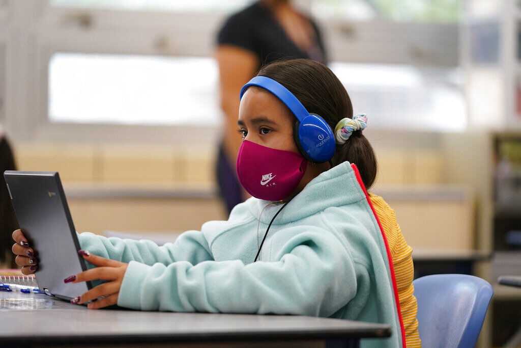 Reyna Najera works on a laptop in a classroom in Newlon Elementary School early Tuesday, Aug. 25, 2020, which is one of 55 Discovery Link sites set up by Denver Public Schools where students are participating in remote learning in this time of the new coronavirus from a school in Denver. (AP Photo/David Zalubowski) (The Associated Press)