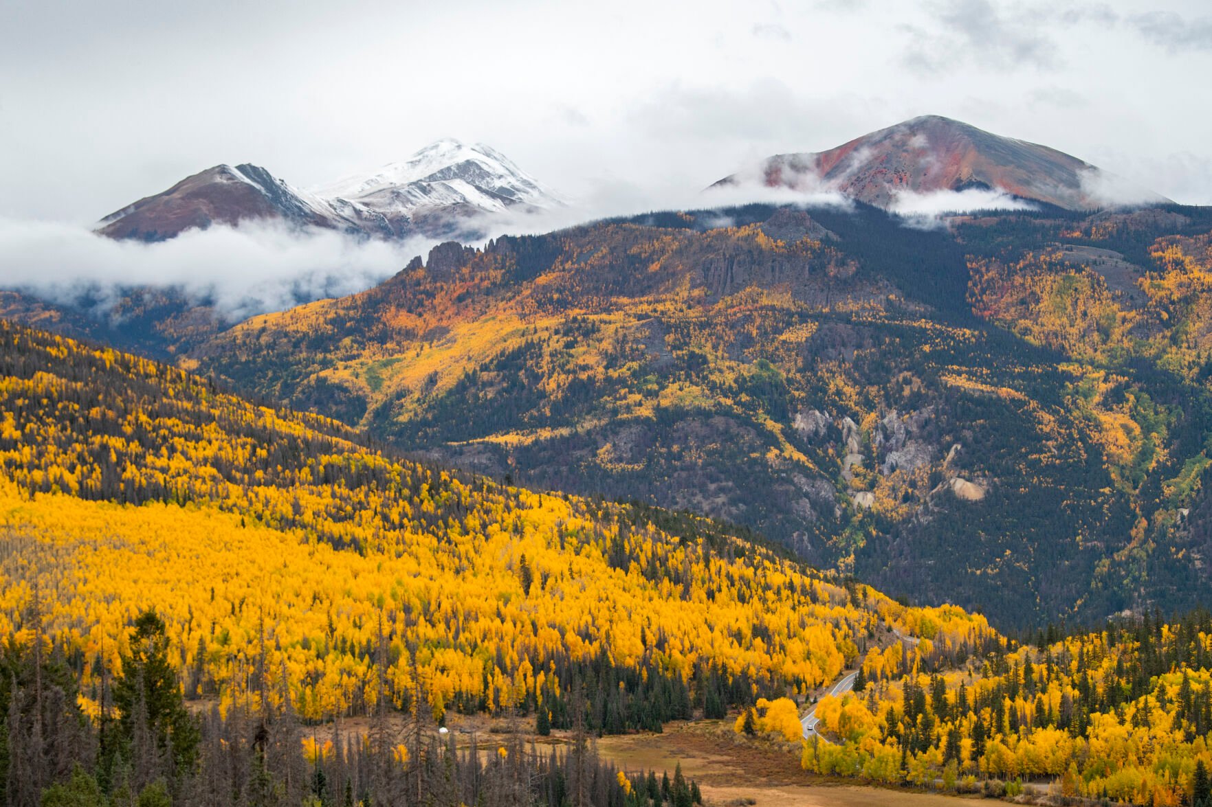 A car drives down 11,530-foot Slumgullion Pass through the changing aspens toward Lake City, Colo., Tuesday, Sept. 28, 2021. (The Gazette, Christian Murdock) (Christian Murdock/The Gazette)