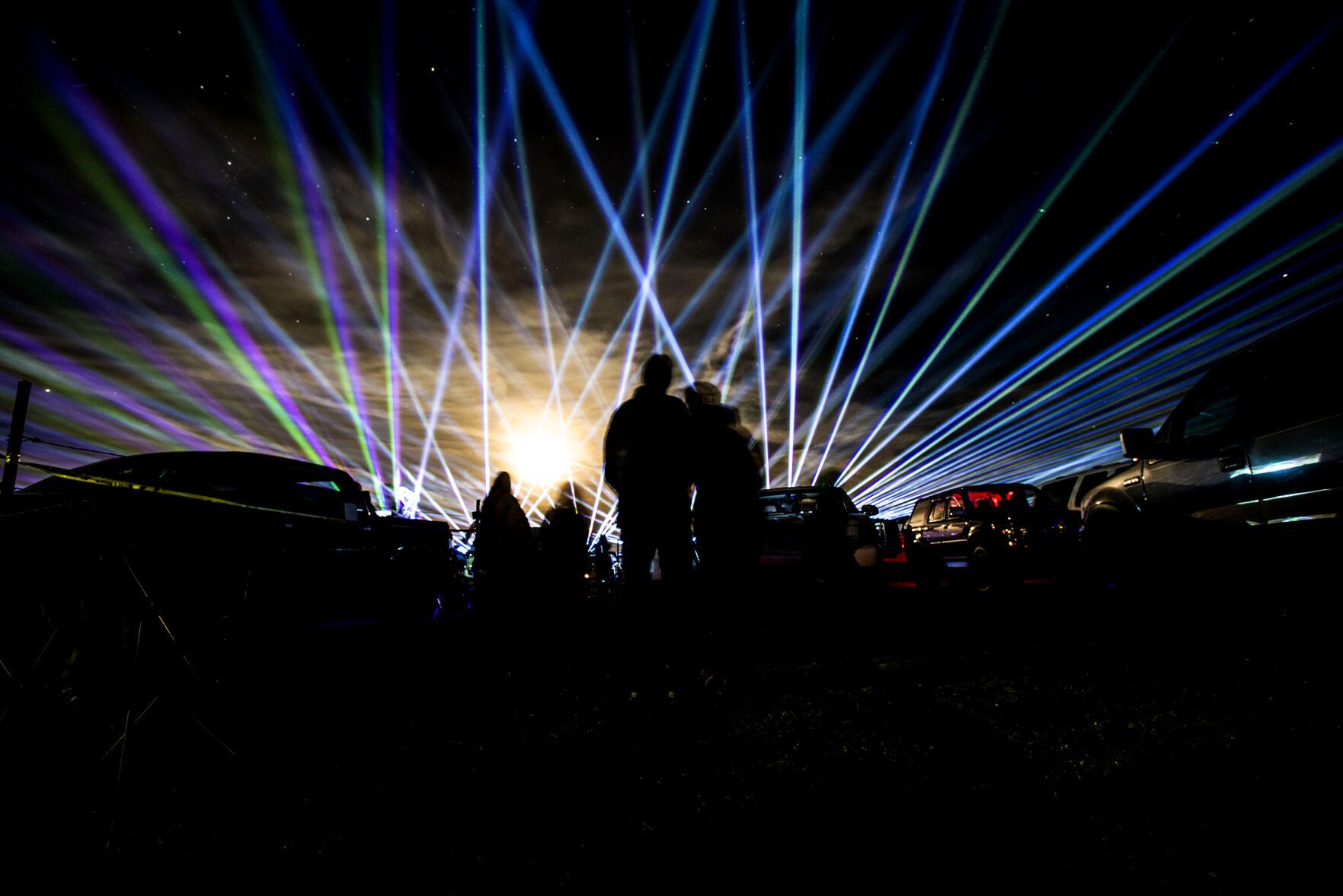 People watch the Cabin Fever Laser Show at the El Paso County Fairgrounds in Calhan, Colo., on Friday, Oct. 22, 2021. The drive-in laser light show was started during the COVID-19 pandemic, offering a unique socially distance entertainment experience. The show includes 25 high-powered lasers and DUAL large screen Laser projection. The last show is Sunday at 7:30pm. (Chancey Bush / The Gazette) (Chancey Bush/ The Gazette)