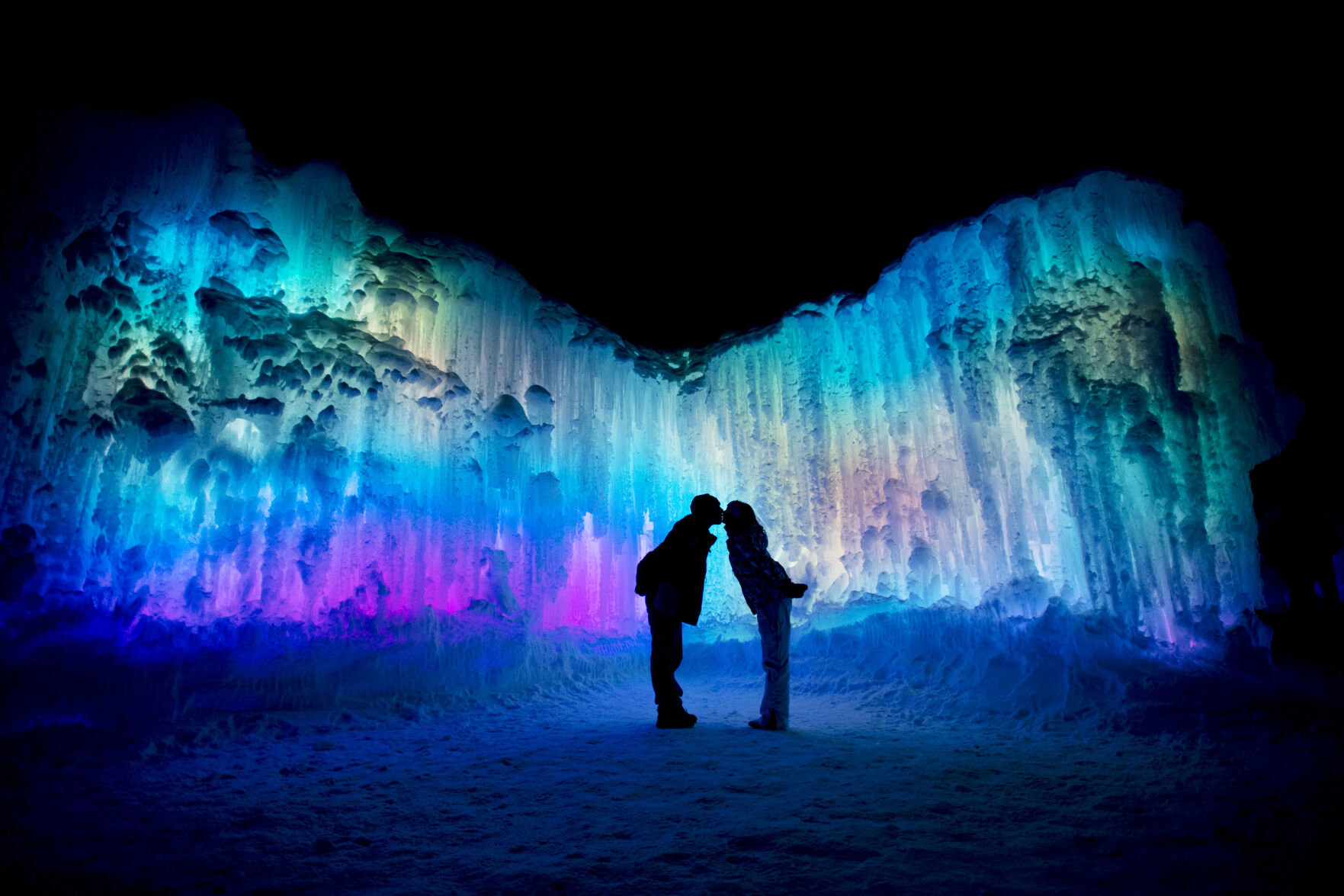 Chris Oberle and Kristen Ergenbright of Denver give each other a kiss as they pose for their friends at the Ice Castles in Dillon, Colo., on Friday, Jan. 17, 2020. (Chancey Bush, The Gazette)