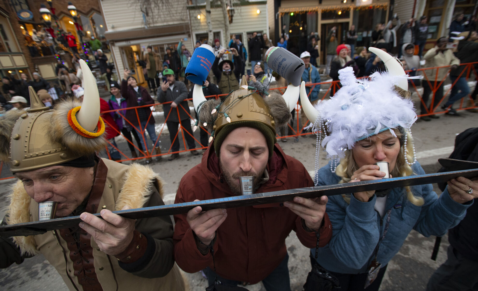 Cliff Black, left, his son Justin Black and wife Sheila Black of Colorado Springs, take a shot of whiskey while the town of Breckenridge attempts to break the shot ski record with 1,333 participants before the start of the Ullr Festival parade Thursday, Dec. 9, 2021 in downtown Breckenridge, Colo. The 58th annual Ullr Festival, named after the Norse god of snow, began Thursday night and runs through Dec. 12. (The Gazette, Christian Murdock) (Christian Murdock/The Gazette)
