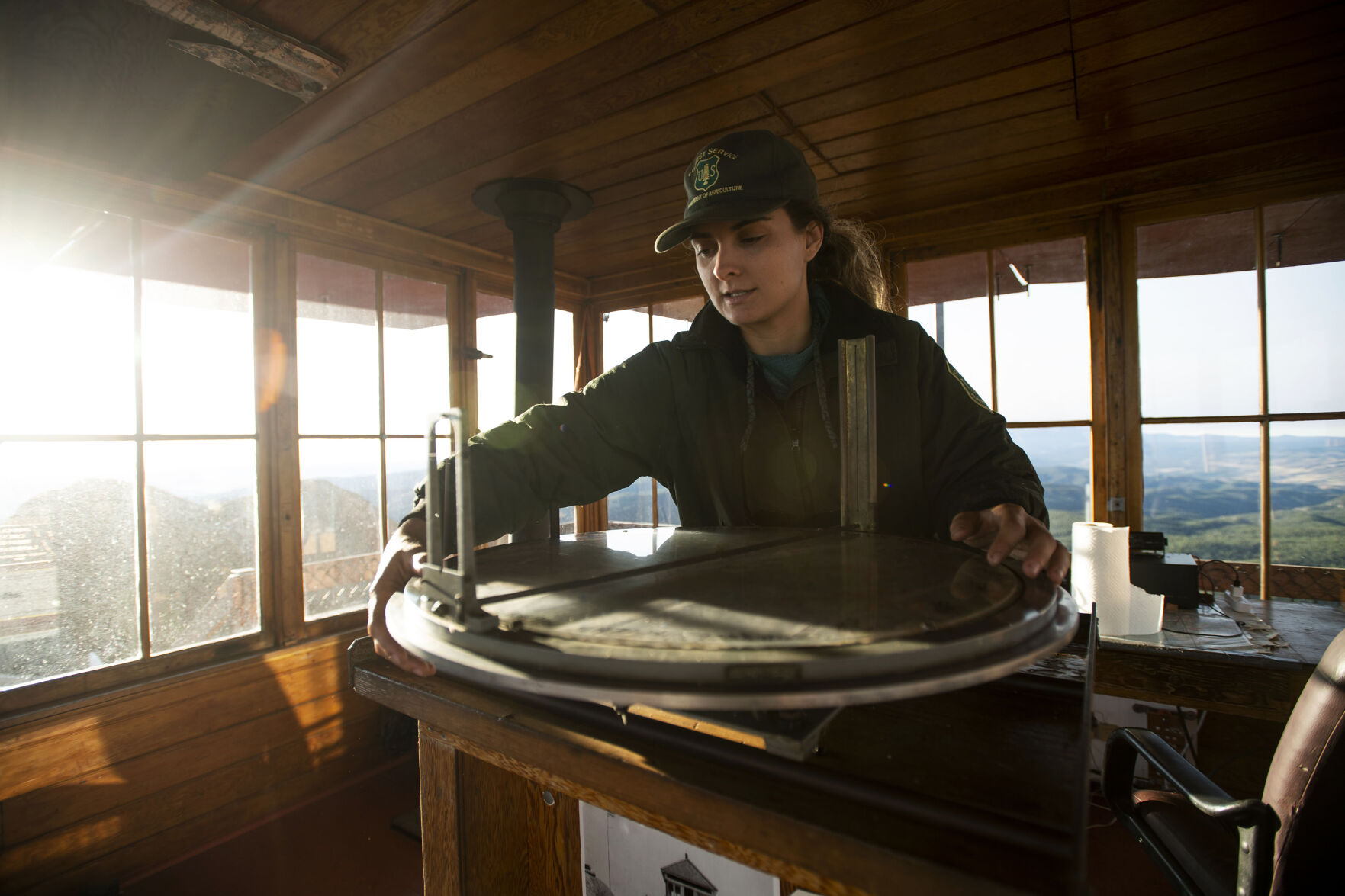 Ashley Farinacci-Silfies, 27, uses an Osborne firefinder to determine the location of smoke detected at the Devil’s Head Fire Lookout Tower outside of Sedalia in the Pike National Forest. The lookout stands at 9,748 feet in elevation and is the last of four original Front Range fire lookout towers still in operation. (Chancey Bush/The Gazette)