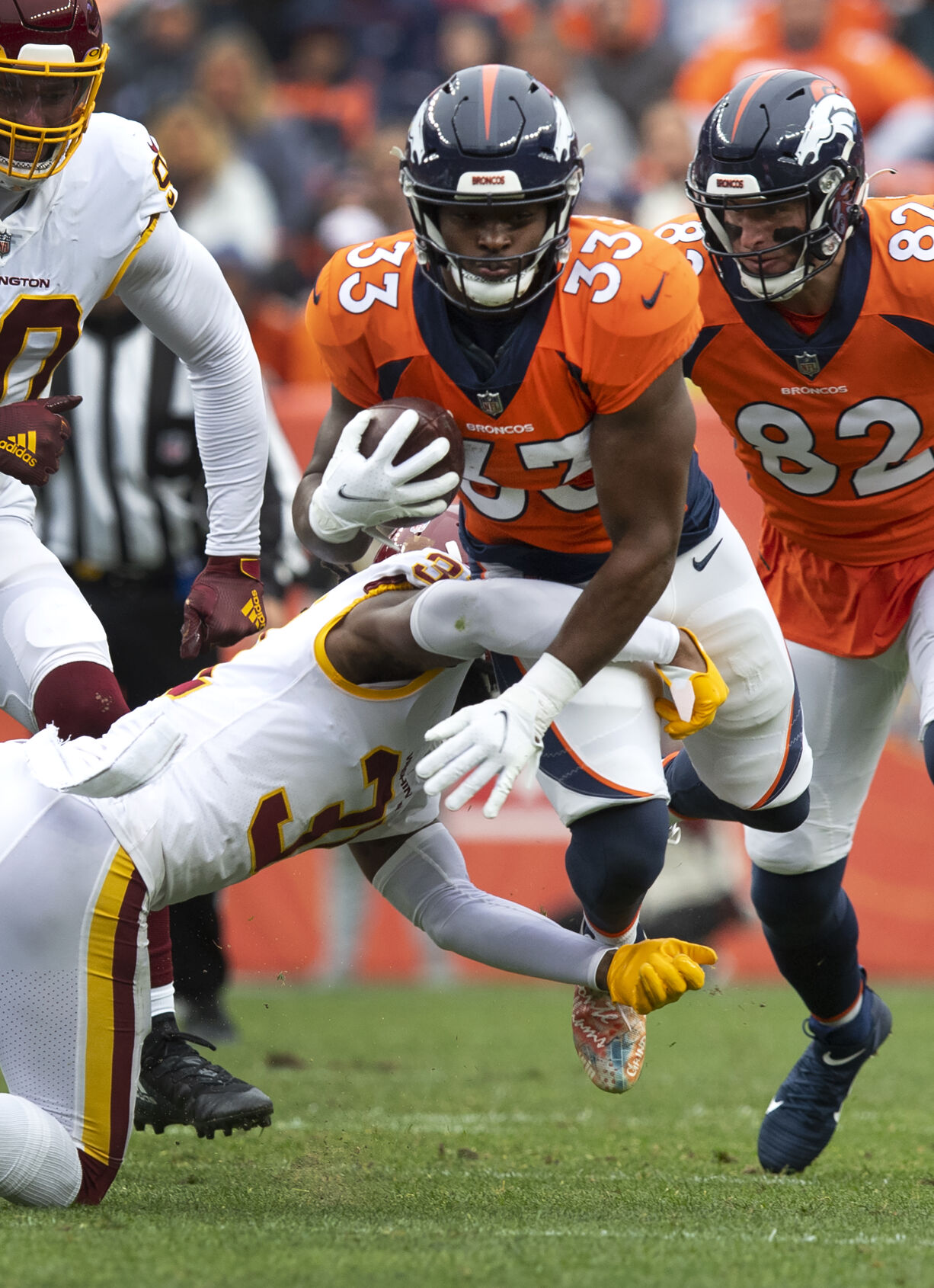 Denver Broncos running back Javonte Williams (33) runs past Washington Football Team free safety Kamren Curl (31) during the second quarter Sunday, Oct. 31, 2021, at Empower Field at Mile High in Denver. (The Gazette, Christian Murdock) (Christian Murdock/The Gazette)