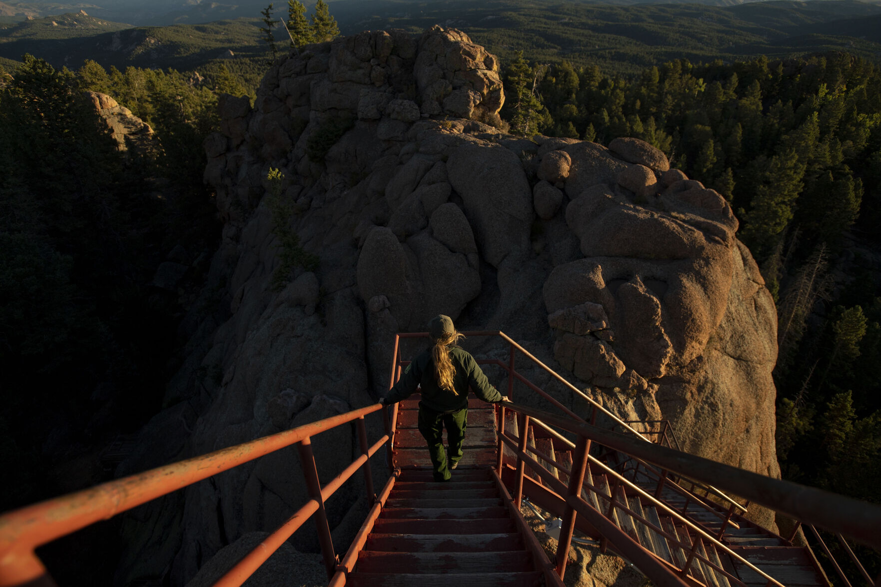 Farinacci-Silfies, 27, walks down the wooden stairs of the Devil’s Head Lookout Tower outside of Sedalia in the Pike National Fores Sept. 23, 2021. Farinacci-Silfies job is to detect smoke and report the location of potential fires atop the tower that stands at 9,748 feet in elevation. Devil’s Head Lookout is the last of four original Front Range fire lookout towers still in operation. Farinacci-Silfies just finished up her second season after taking over the duty from Bill Ellis, who finished his 35th season and retired at the age of 87. (Chancey Bush/The Gazette)