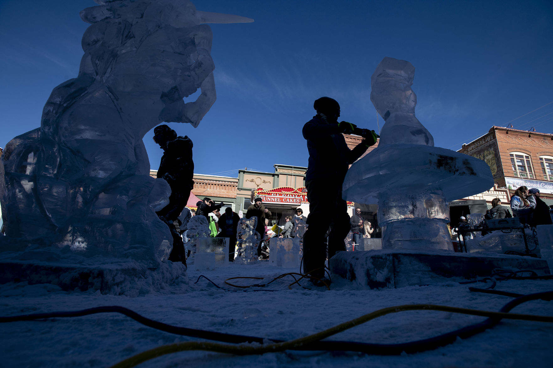 Luan Bui, left, and Julie Eslinger, right, work on their sculptures as part of team Ice Cubed of Denver's Mystical Creatures theme during the 13th annual Cripple Creek Ice Festival in Cripple Creek, Colo., on Saturday, Feb. 8, 2020. (Chancey Bush/ The Gazette) (Chancey Bush The Gazette)