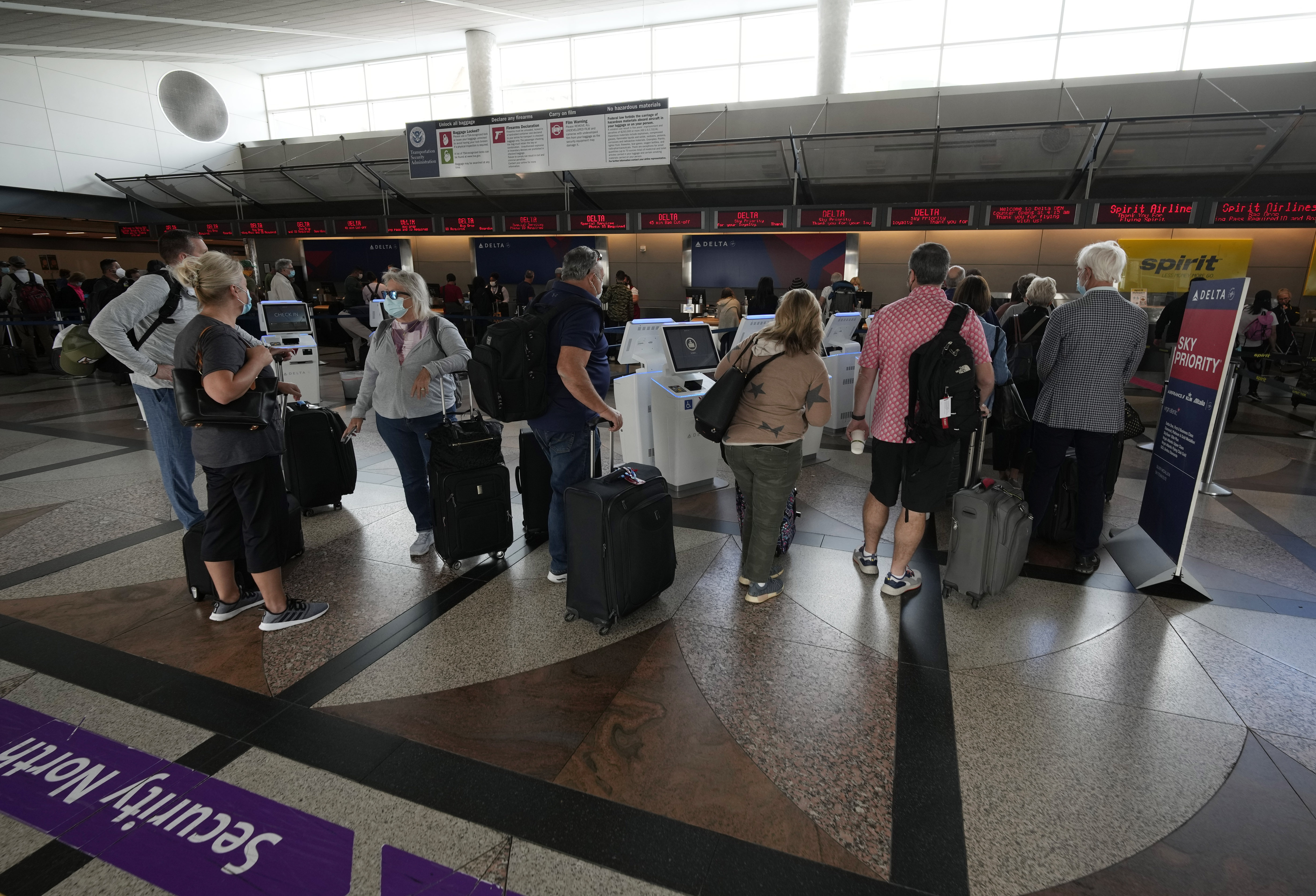 Travelers wait to approach the ticketing counter for Delta Air Lines at Denver International Airport, Tuesday, Sept. 14, 2021, in Denver. (David Zalubowski - staff, AP)