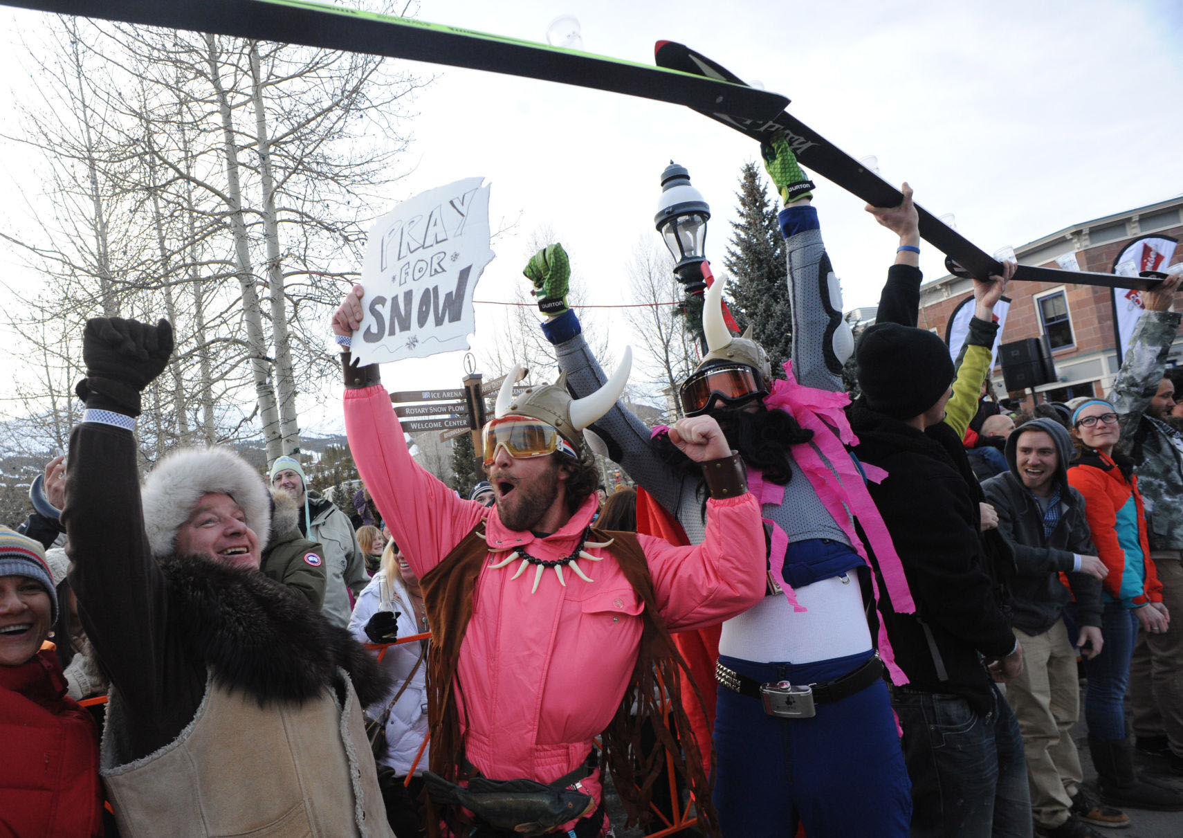 Kevin Flesher, left, of Colorado Springs joins locals Jake Sklanka, center, Brett Lomoro and about 170 other parade goers as they celebrate along the 313-foot, 6-inch shot ski after they broke the world record for longest shot ski before the Ullr Fest Parade. (The Gazette, Christian Murdock)