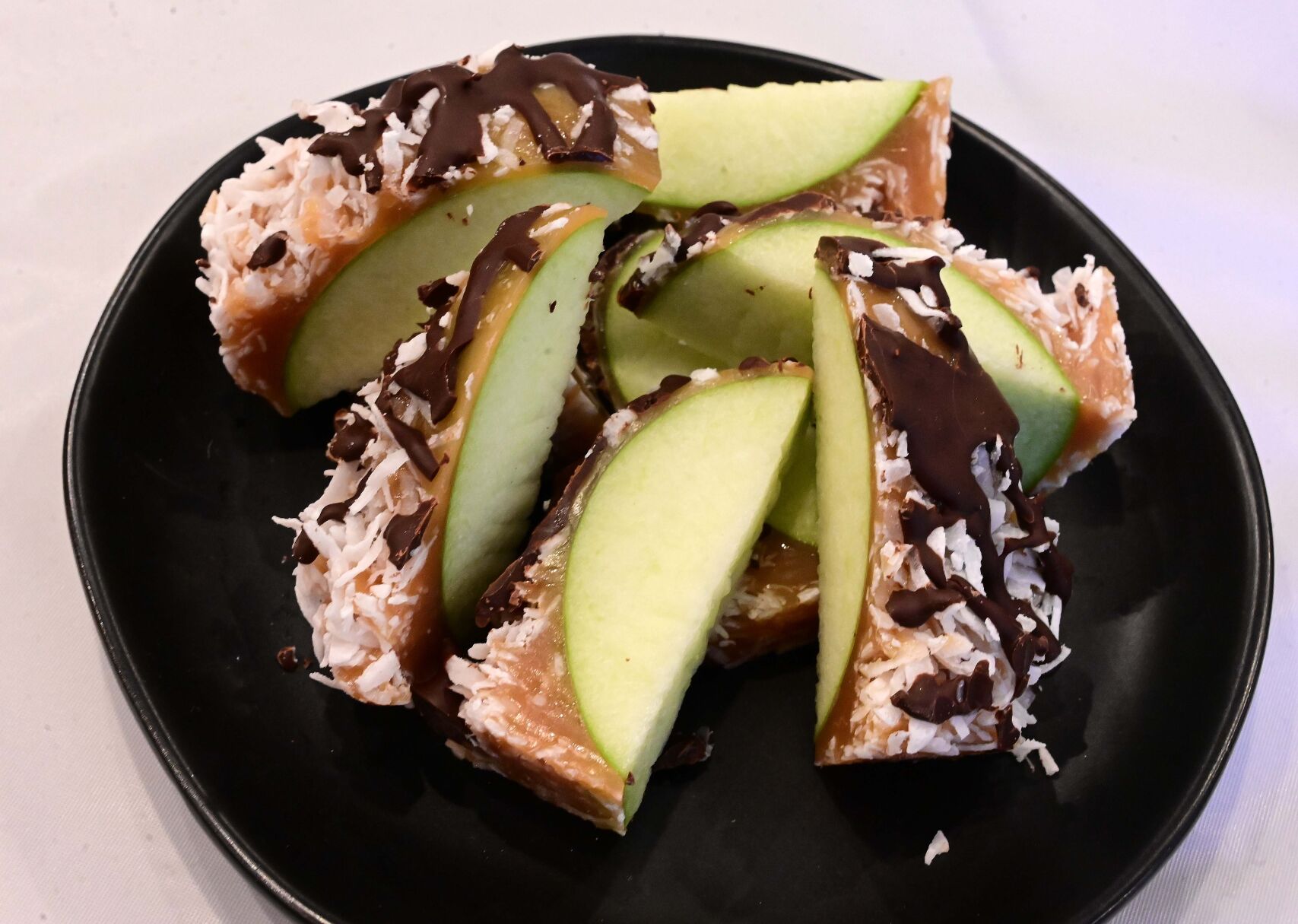 Caramel apples aren’t made with just caramel anymore. This apple was covered in caramel, coconut and chocolate. Made by Sweet Addict Bakery. (Jerilee Bennett, The Gazette)