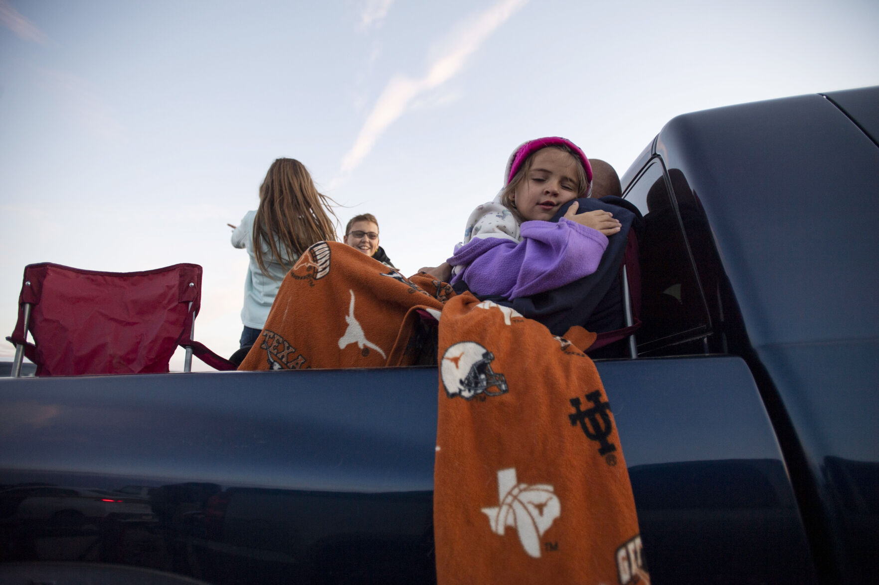 The Teague family, from Calhan hangout in the back of their truck bed before the start of the Cabin Fever Laser Show at the El Paso County Fairgrounds in Calhan, Colo., on Friday, Oct. 22, 2021. The drive-in laser light show was started during the COVID-19 pandemic, offering a unique socially distance entertainment experience. The show includes 25 high-powered lasers and DUAL large screen Laser projection. The last show is Sunday at 7:30pm. (Chancey Bush / The Gazette) (Chancey Bush/ The Gazette)