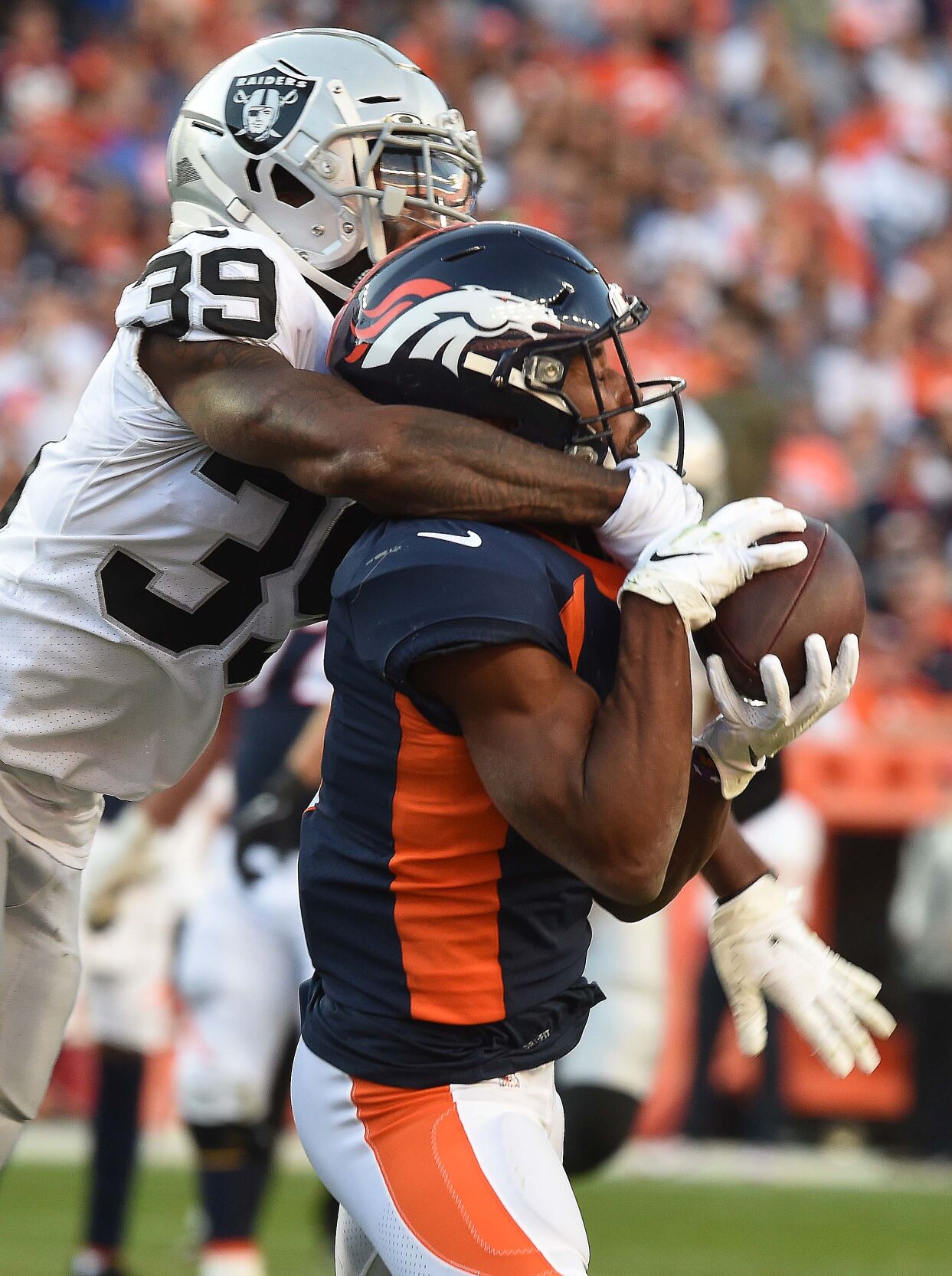 Broncos wide receiver Kendall Hinton hauls in a catch while being defended by Raiders cornerback Nate Hobbs during the fourth quarter at Empower Field at Mile High Stadium on Sunday, Oct. 17, 2021. The Broncos were defeated 34-24. (Photo by Jerilee Bennett, The Gazette)