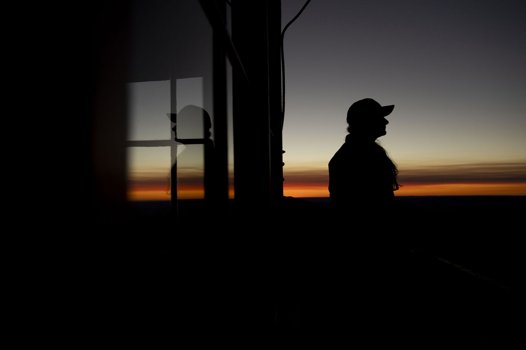 Ashley Farinacci-Silfies, 27, views the area as the sun rises at the Devil’s Head Fire Lookout Tower outside of Sedalia in the Pike National Forest. The lookout stands at 9,748 feet in elevation and is the last of four original Front Range fire lookout towers still in operation. Farinacci-Silfies just finished up her second season after taking over the duty from Bill Ellis, who finished his 35th season and retired at the age of 87. (Chancey Bush/The Gazette)