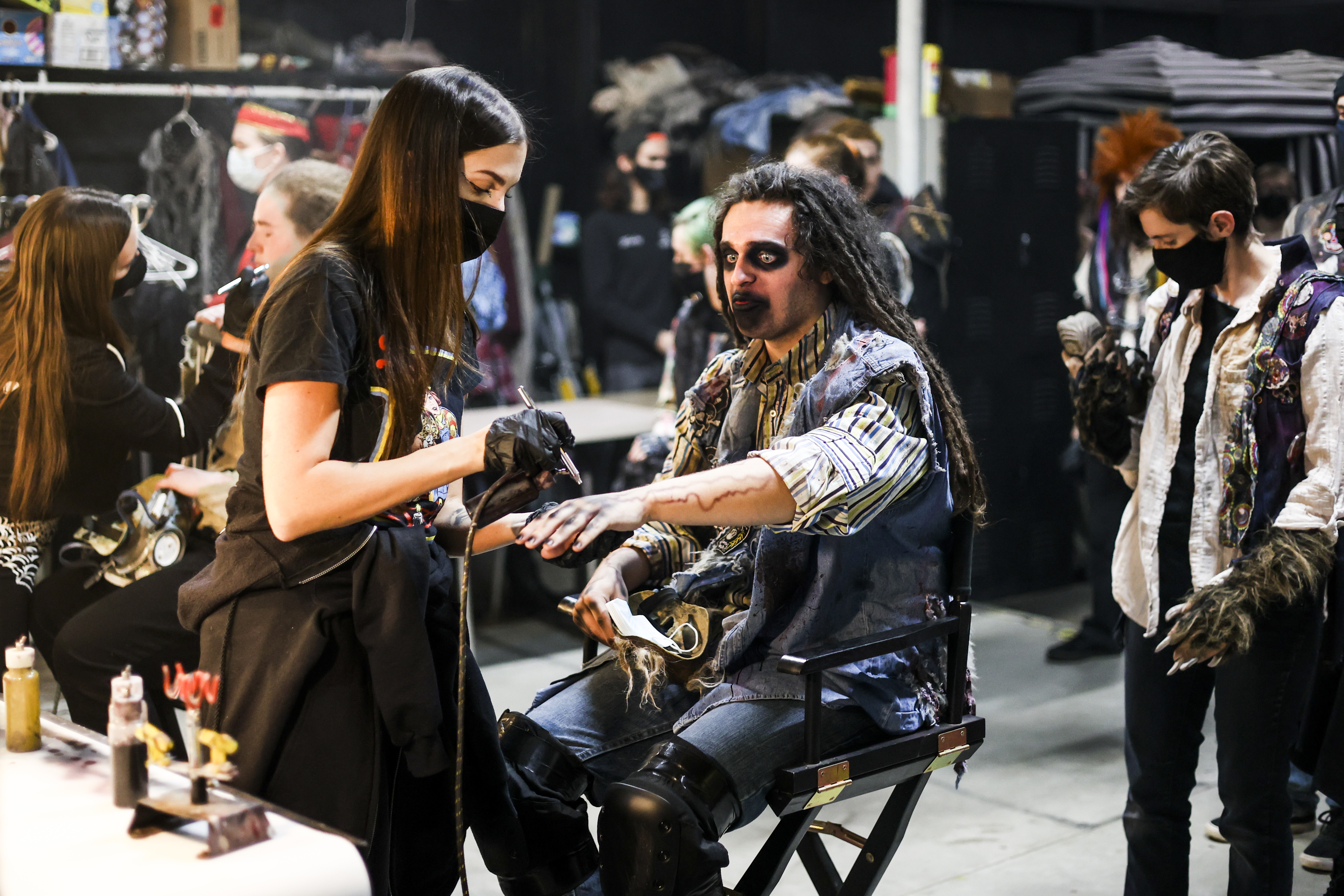 Makeup artist Julianna Casimiro, left, does the makeup of performer Quentin Toetz before guests arrive at 13th Floor Haunted House on Tuesday, Oct. 12, 2021 in Denver. (Michael Ciaglo/Special to The Denver Gazette)