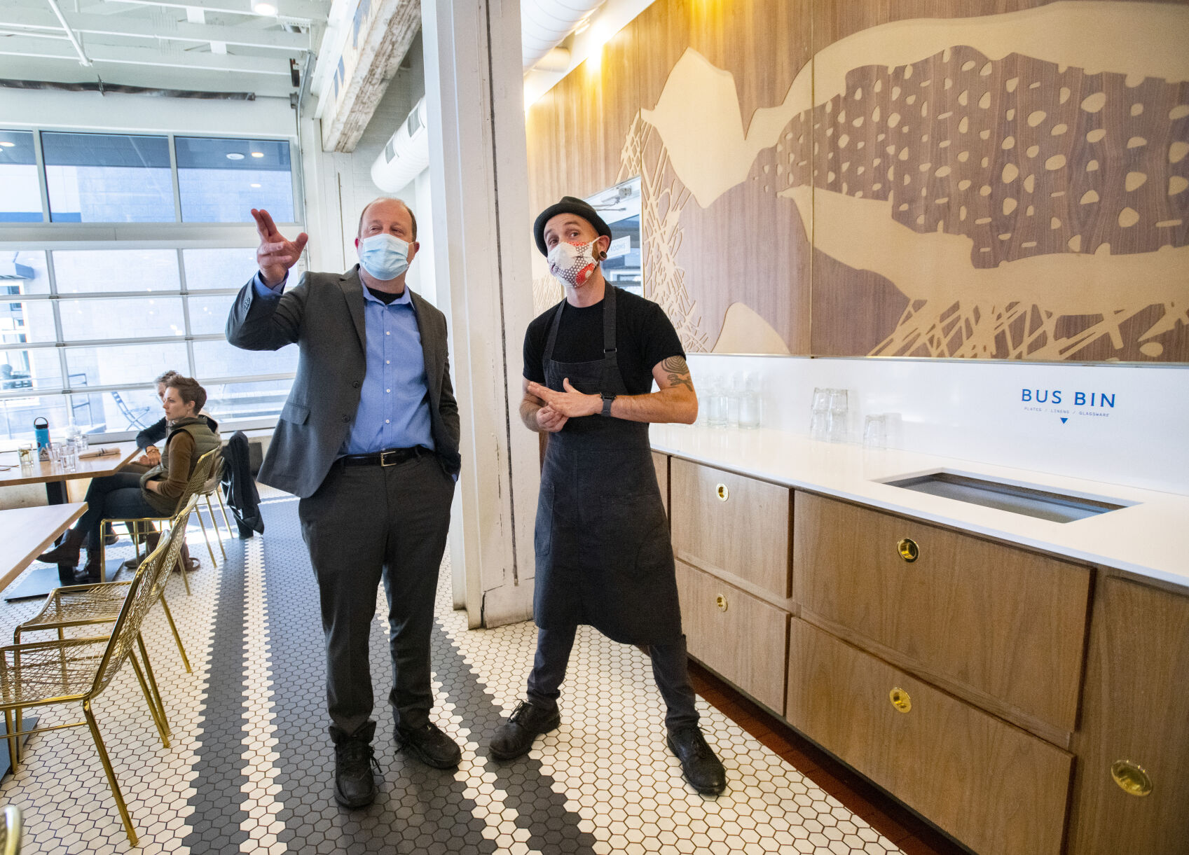 Gov. Jared Polis, left, talks with Eric Nicol, one of the owners of Loyal Coffee, while visiting the coffee shop in downtown Colorado Springs on Friday. (Christian Murdock/The Gazette)