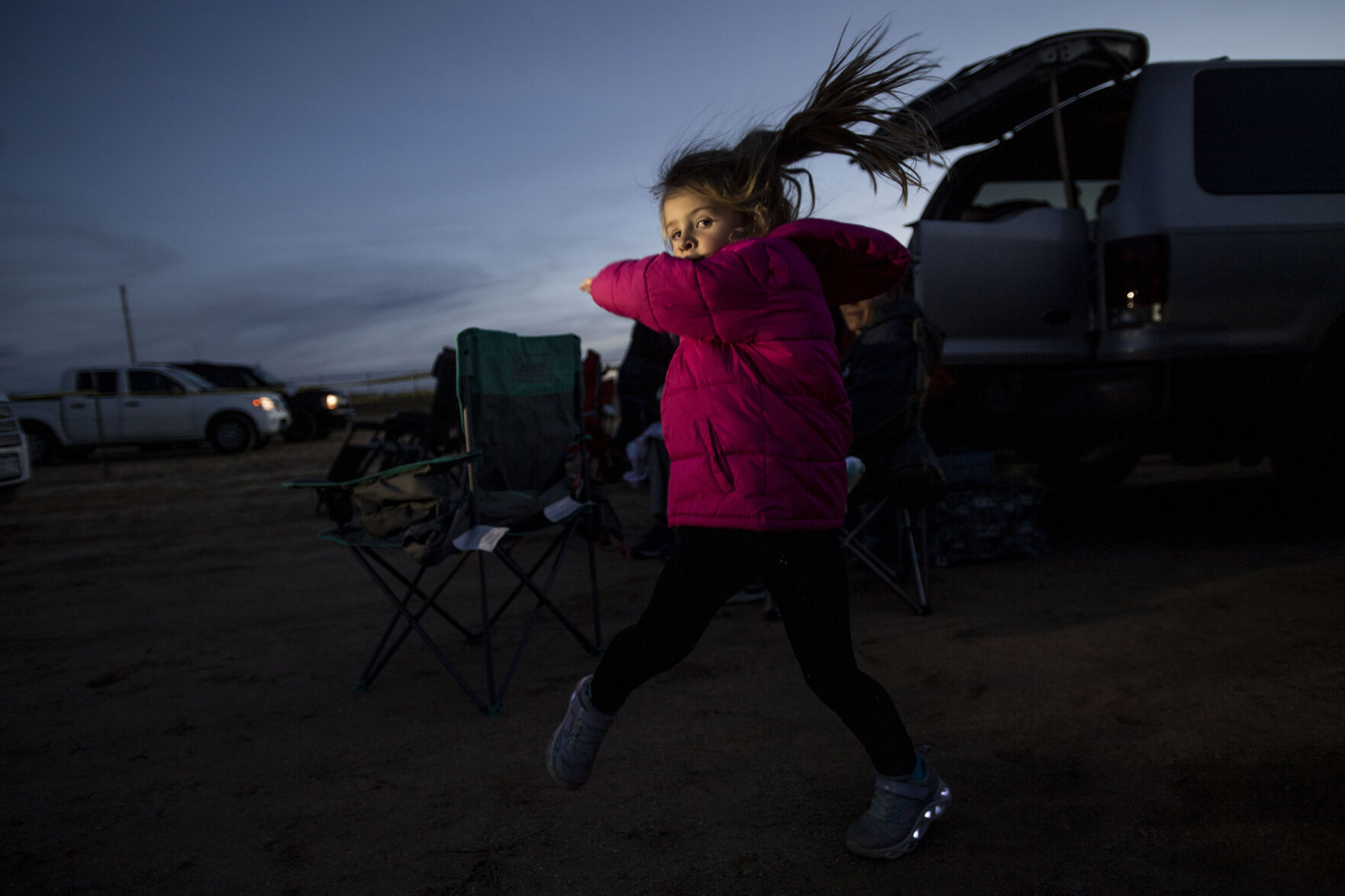 Junie Ahlers, 4, from Nebraska, dances around before the start of the Cabin Fever Laser Show at the El Paso County Fairgrounds in Calhan, Colo., on Friday, Oct. 22, 2021. The drive-in laser light show was started during the COVID-19 pandemic, offering a unique socially distance entertainment experience. The show includes 25 high-powered lasers and DUAL large screen Laser projection. The last show is Sunday at 7:30pm. (Chancey Bush / The Gazette) (Chancey Bush/ The Gazette)