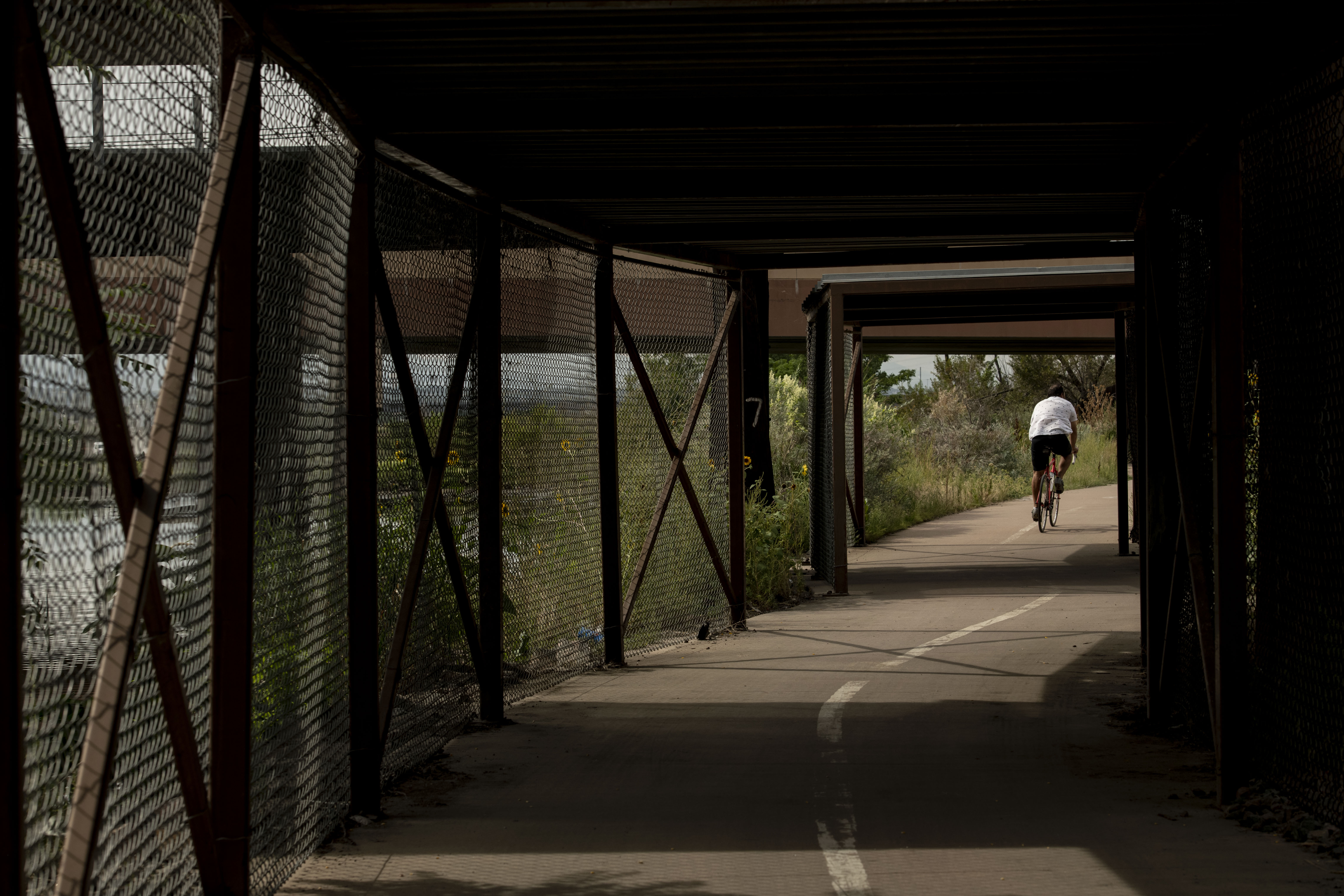 A bicyclist rides near the Suncor Energy oil refinery in Commerce City on August 26, 2021. (Chancey Bush/ The Denver Gazette)