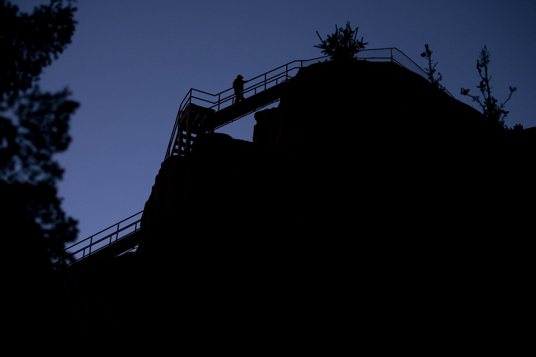 Ashley Farinacci-Silfies, 27, climbs the stairs to the top of Devil’s Head Fire Lookout Tower at dawn on Sept. 23, 2021. Farinacci-Silfies job is to detect smoke and report the location of potential fires atop the tower that stands at 9,748 feet in elevation. The lookout is the last of four original Front Range fire lookout towers still in operation. Farinacci-Silfies just finished up her second season after taking over the duty from Bill Ellis, who finished his 35th season and retired at the age of 87. (Chancey Bush/The Gazette)