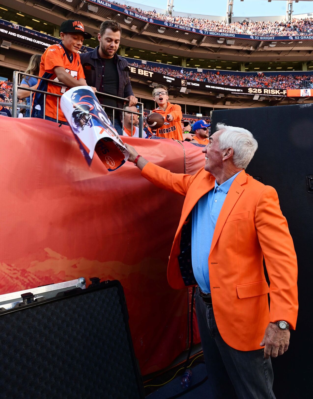 Many Broncos greats were in the house for Sunday’s game against the Raiders. Former Broncos Head Coach Mike Shanahan was added to the Ring of Fame. Shanahan signs a poster for Bronco fan before a ceremony at halftime on Sunday, Oct. 17, 2021. Shanahan was the winningest coach in Bronco history and took them to two winning Superbowls. The Broncos were defeated 34-24. (Photo by Jerilee Bennett, The Gazette)
