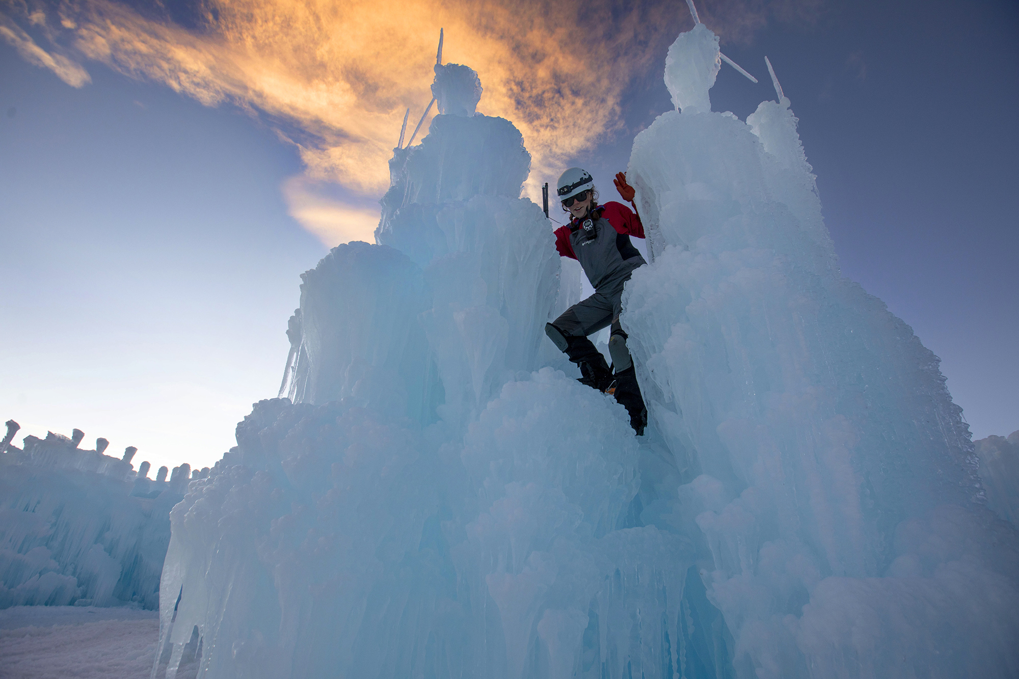 Betsy Horton climbs down an ice sculpture after placing icicles on top inside the Dillon Ice Castles in Dillonin 2020. (Chancey Bush/ The Gazette)