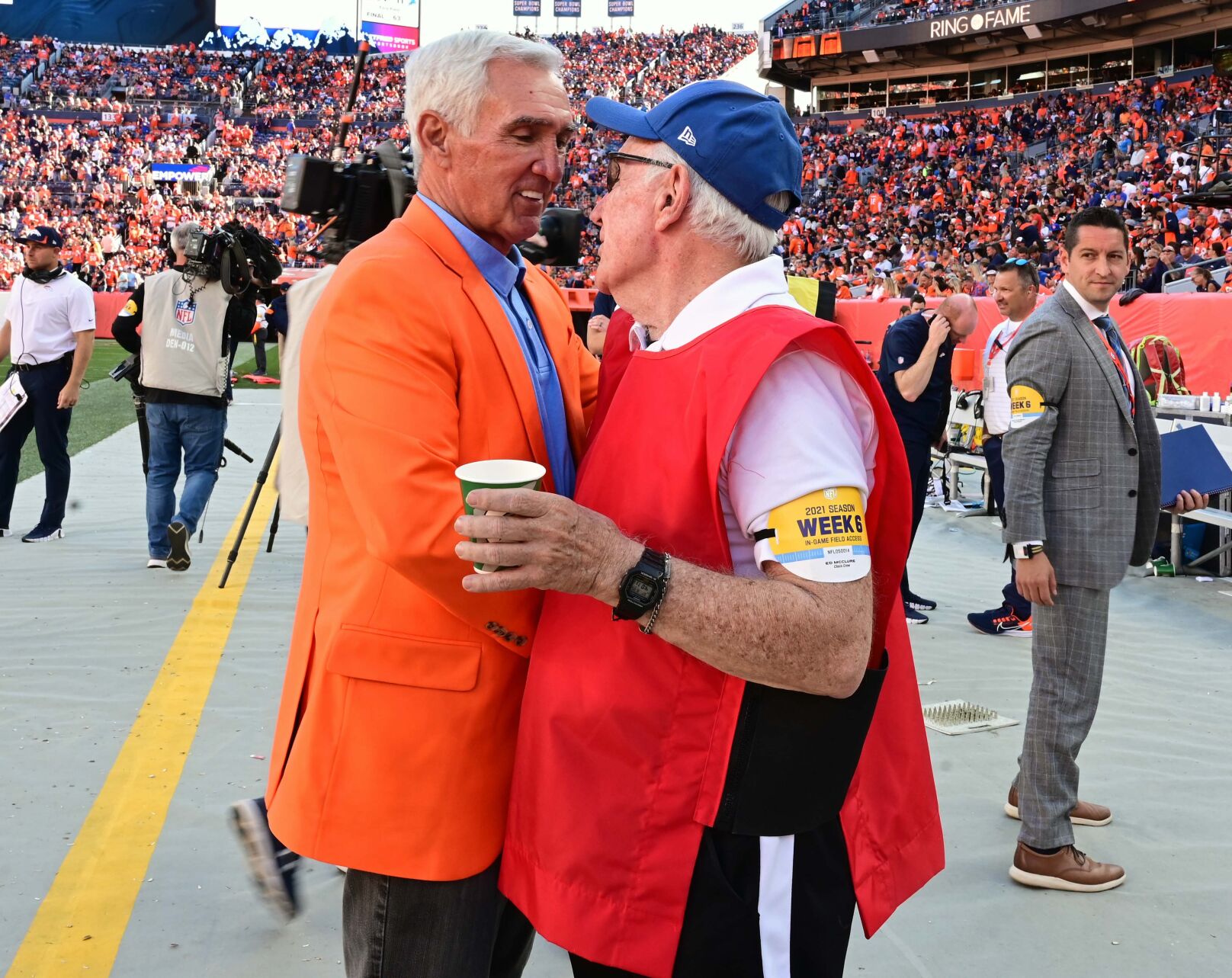 Former Broncos Head Coach Mike Shanahan stop to chat with Ed McClure, who has worked on the sidelines for nearly fifty years, at Empower Field at Mile High Stadium on Sunday, Oct. 17, 2021.Shanahan is the winningest coach in Bronco historians and had his name added to the Ring of Fame during a halftime ceremony. (Photo by Jerilee Bennett, The Gazette)