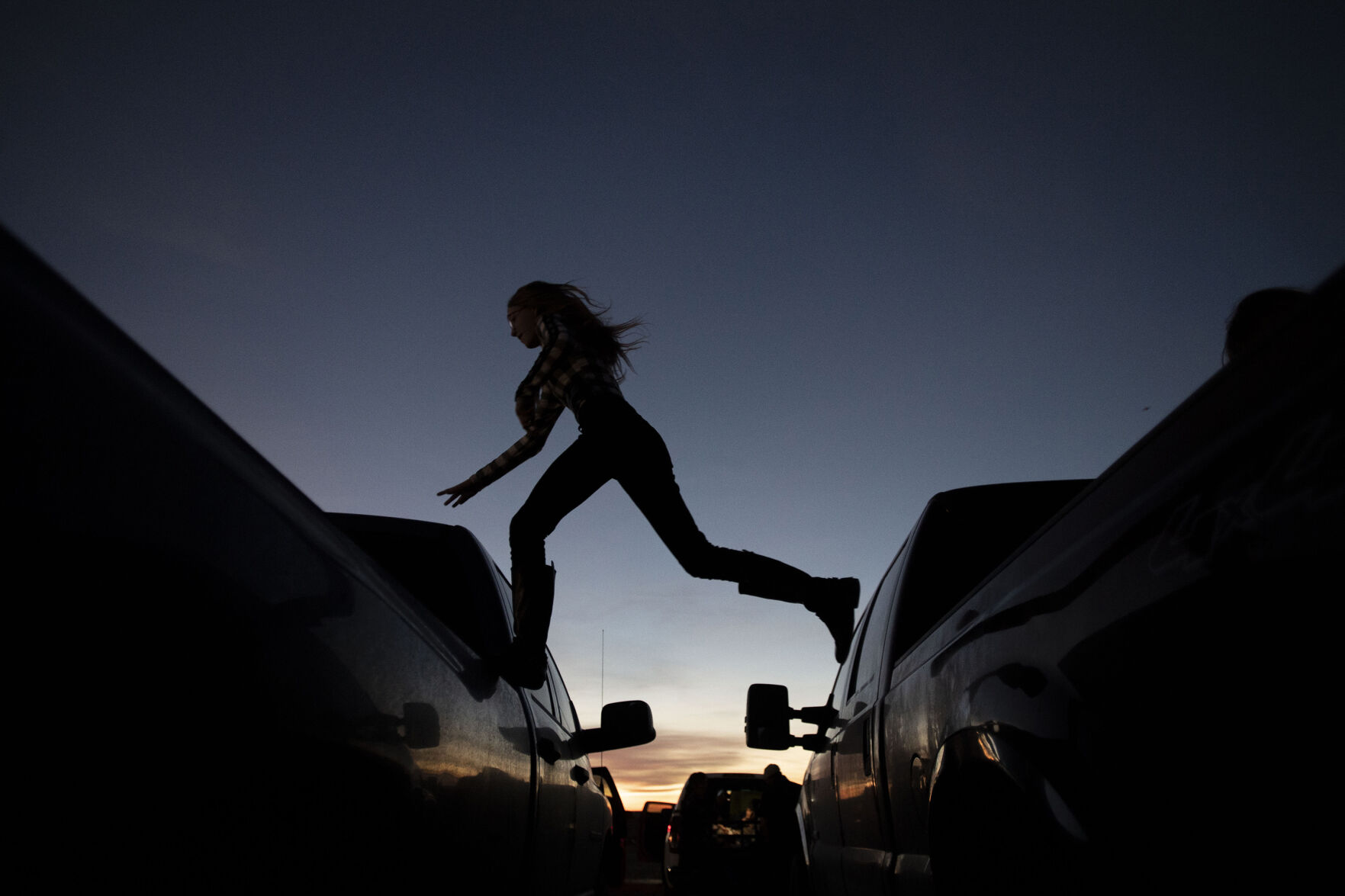 Cheyenne Bowman, 15, crosses to another vehicle before the start of the Cabin Fever Laser Show at the El Paso County Fairgrounds in Calhan, Colo., on Friday, Oct. 22, 2021. The drive-in laser light show was started during the COVID-19 pandemic, offering a unique socially distance entertainment experience. The show includes 25 high-powered lasers and DUAL large screen Laser projection. The last show is Sunday at 7:30pm. (Chancey Bush / The Gazette) (Chancey Bush/ The Gazette)