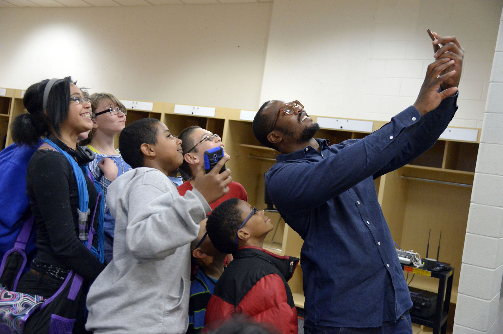 Denver Bronco Von Miller takes a group selfie after a few students received their prescription glasses Monday, April 14, 2014, in Denver. Miller's Foundation, Von's Vision, distributed prescription glass to more than 100 underprivileged Children at Sports Authority Field. (John Leyba via Associated Press)