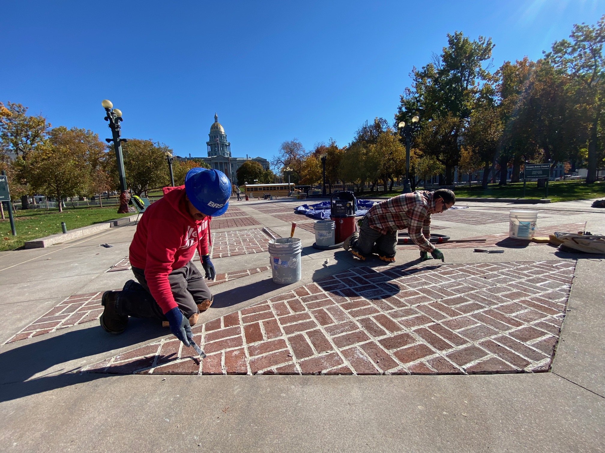 It will take a month for stonemasons Tobias Robles and Armando Martinez to restore old, damaged grout which dot park walkways. (Carol McKinley)