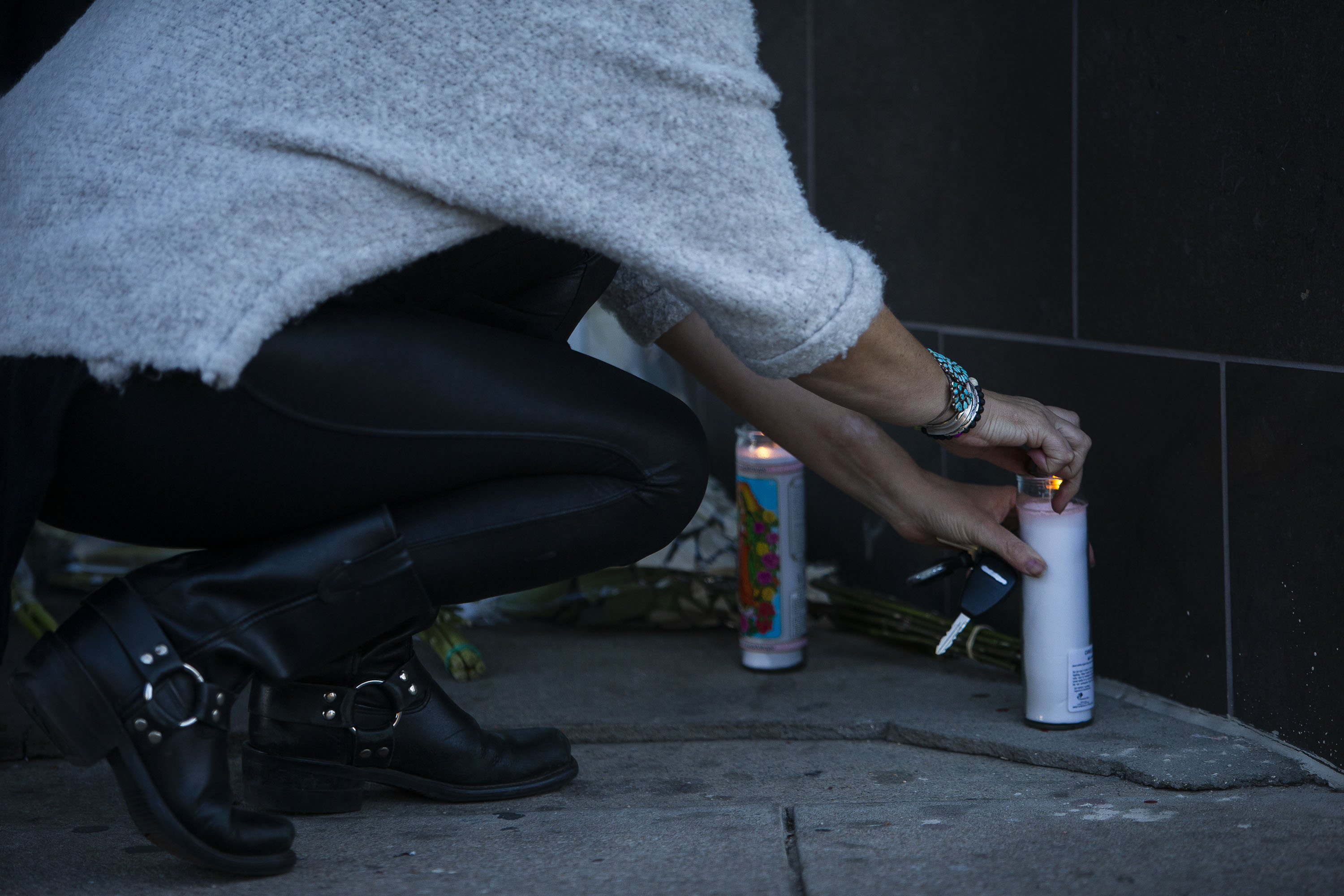 Amy, no last name given, lights a candle in front of Sol Tribe Tattoo & Piercing, which was owned by Alicia Cardenas, one of the victims of a shooting spree the previous night, as seen on Tuesday, Dec. 28, 2021, in Denver, Colo. (Timothy Hurst/The Gazette) (Timothy Hurst)